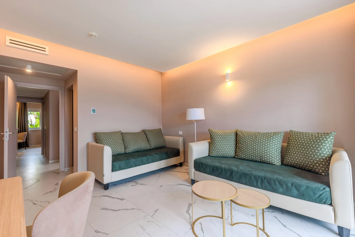 Elegantes Hotelzimmer mit bequemen Sofas, Stehlampe und modernem Design bei Aldiana