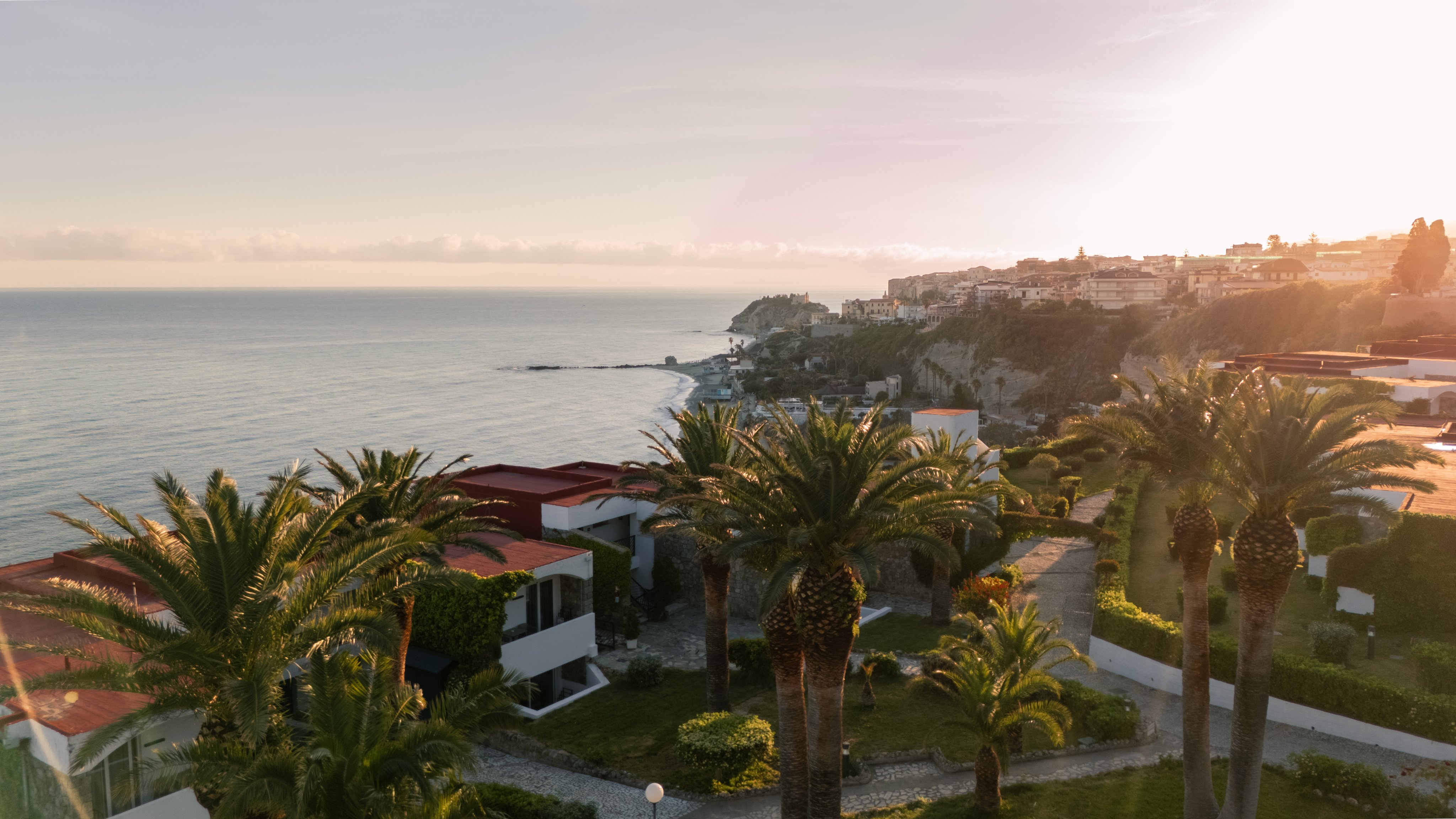 Blick auf ein Luxushotel mit Palmen, Meer und Sonnenuntergang, Urlaub bei Aldiana