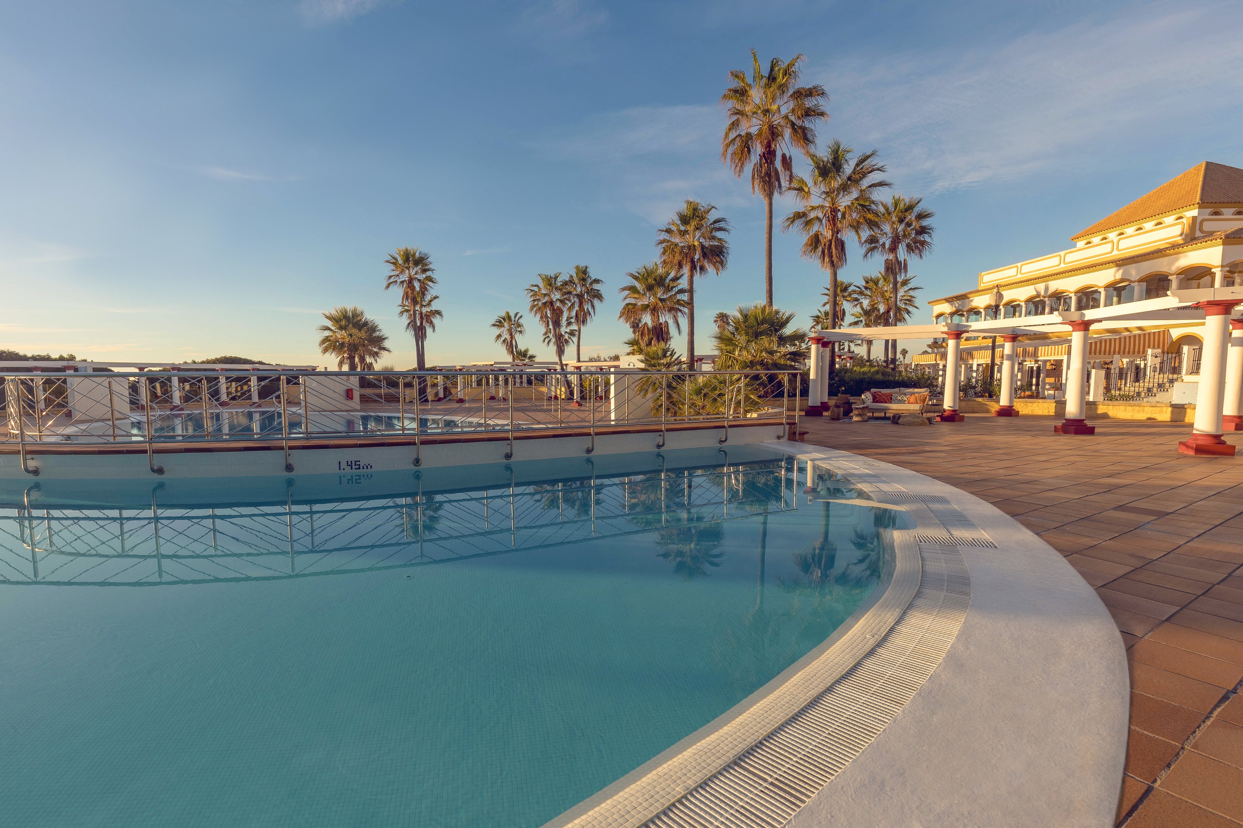 Blick auf Pool und Palmen bei Aldiana, Premium Cluburlaub am Meer.