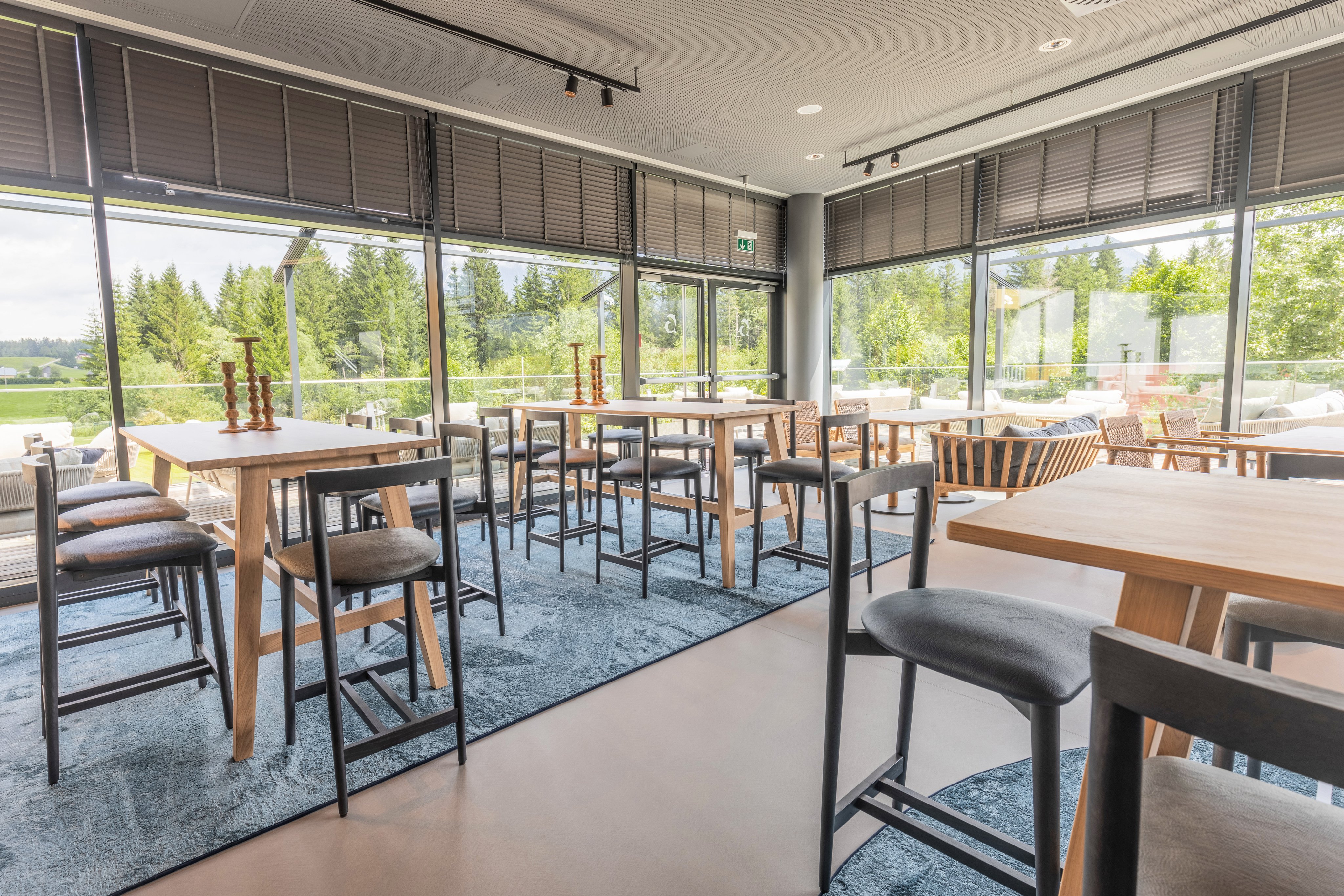 Innenansicht eines modernen, hellen Clubrestaurant bei Aldiana mit großen Fenstern und Holzstühlen