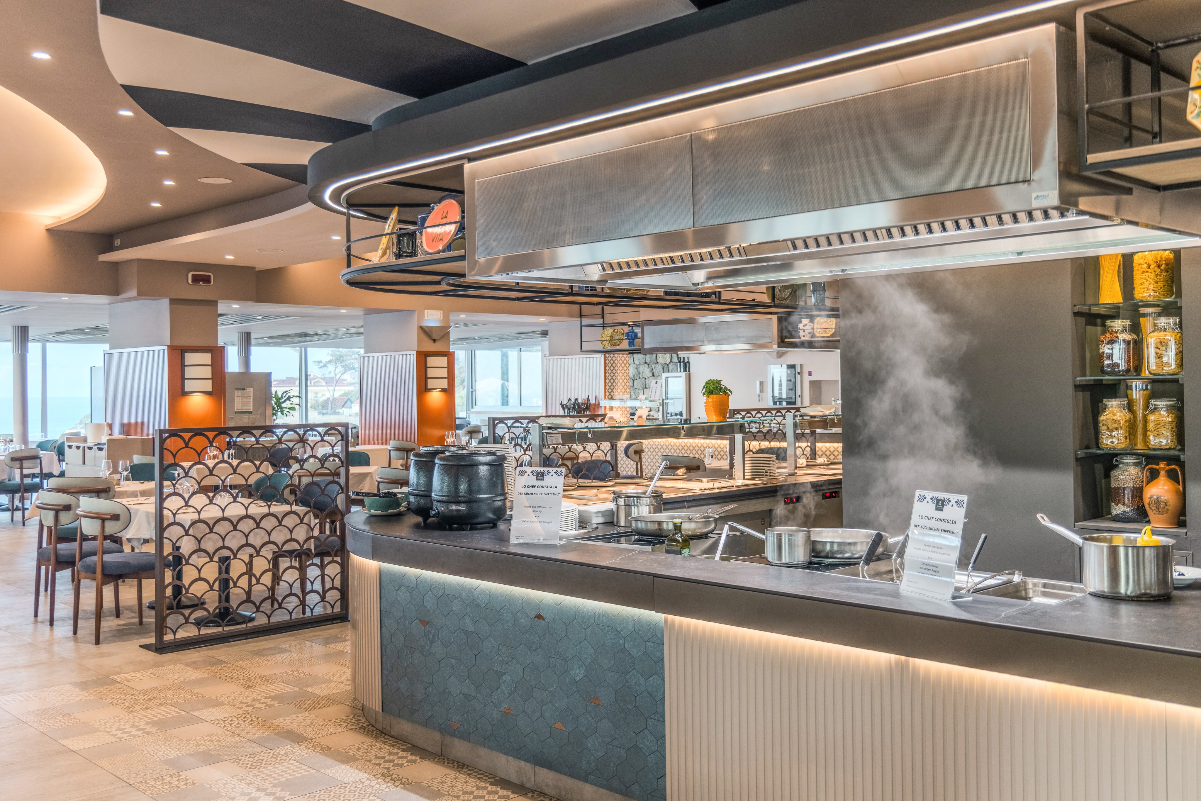 Ein moderner Restaurantbereich bei Aldiana mit Theke, Kochtöpfen und Sitzmöglichkeiten