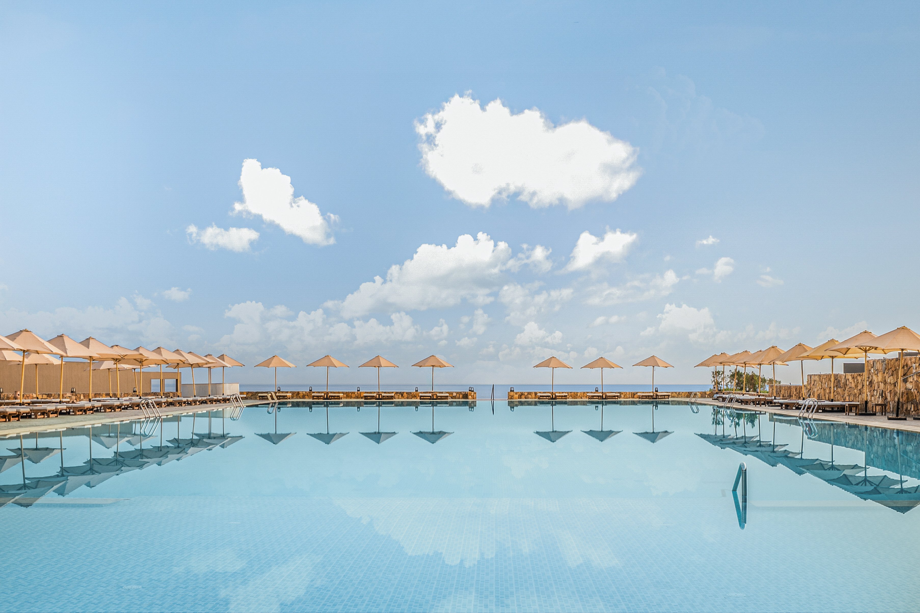 Luxuspool am Meer mit Liegestühlen und Sonnenschirmen bei Aldiana Premium Cluburlaub