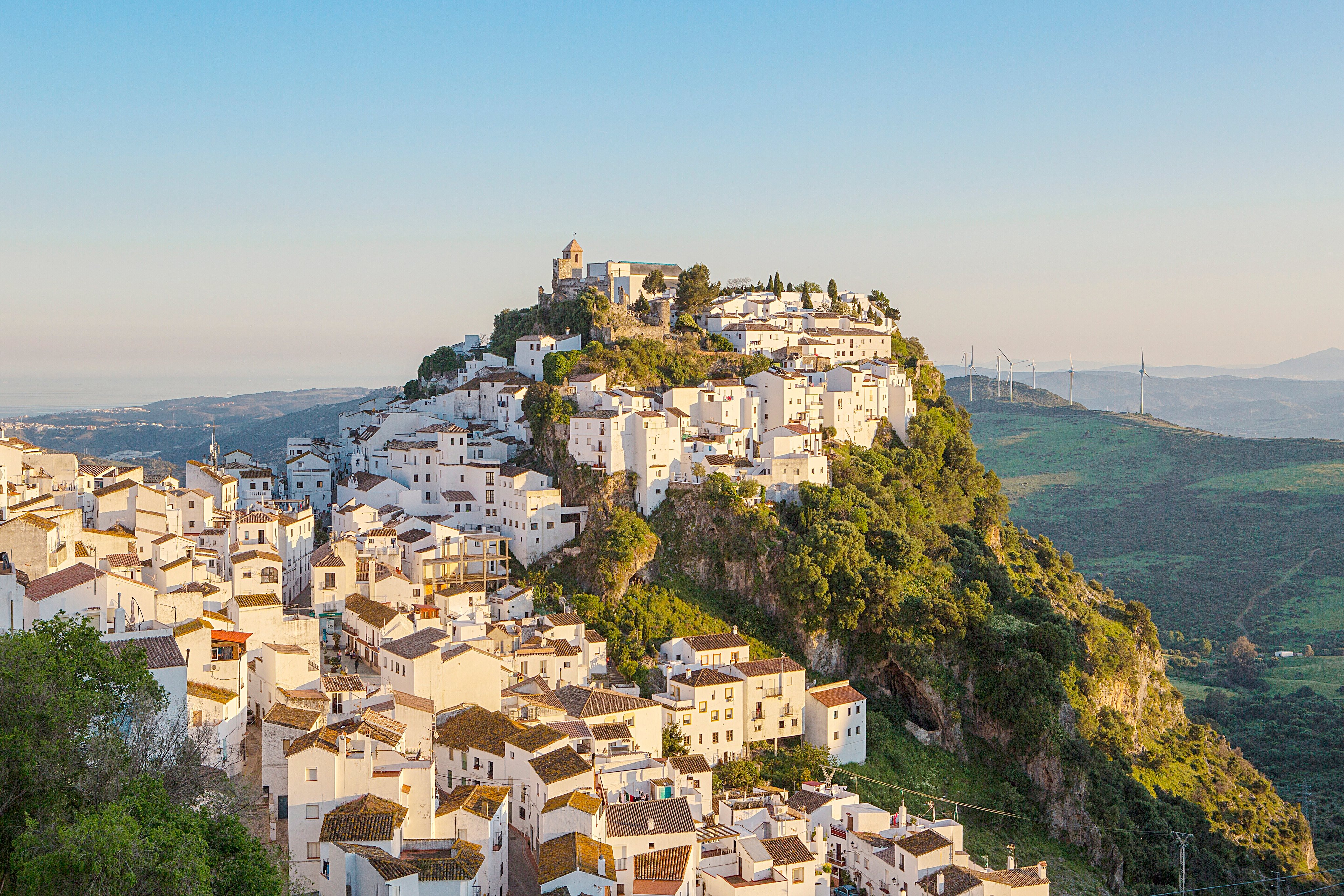 Blick auf eine malerische italienische Stadtsilhouette mit weissem Gebaude und grüner Bergkulisse