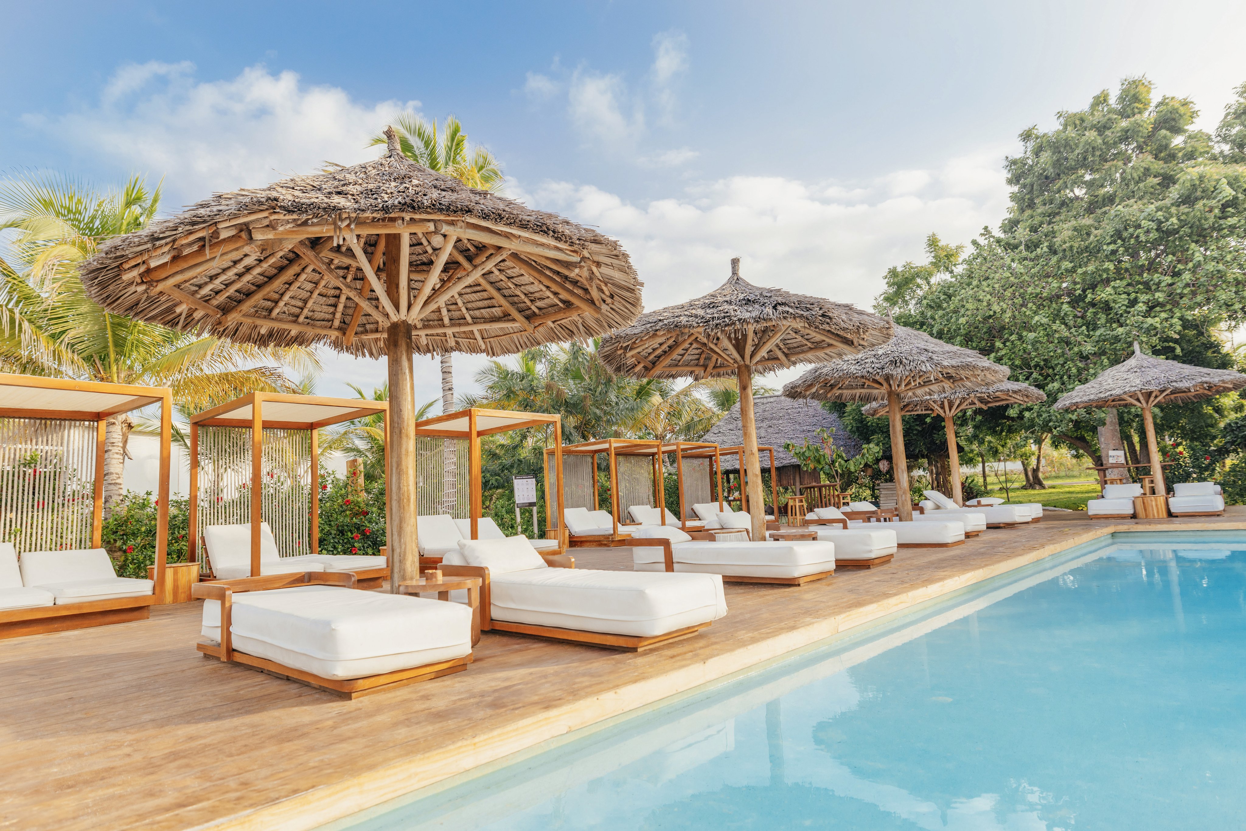 Poolbereich mit Liegen und Sonnenschirmen