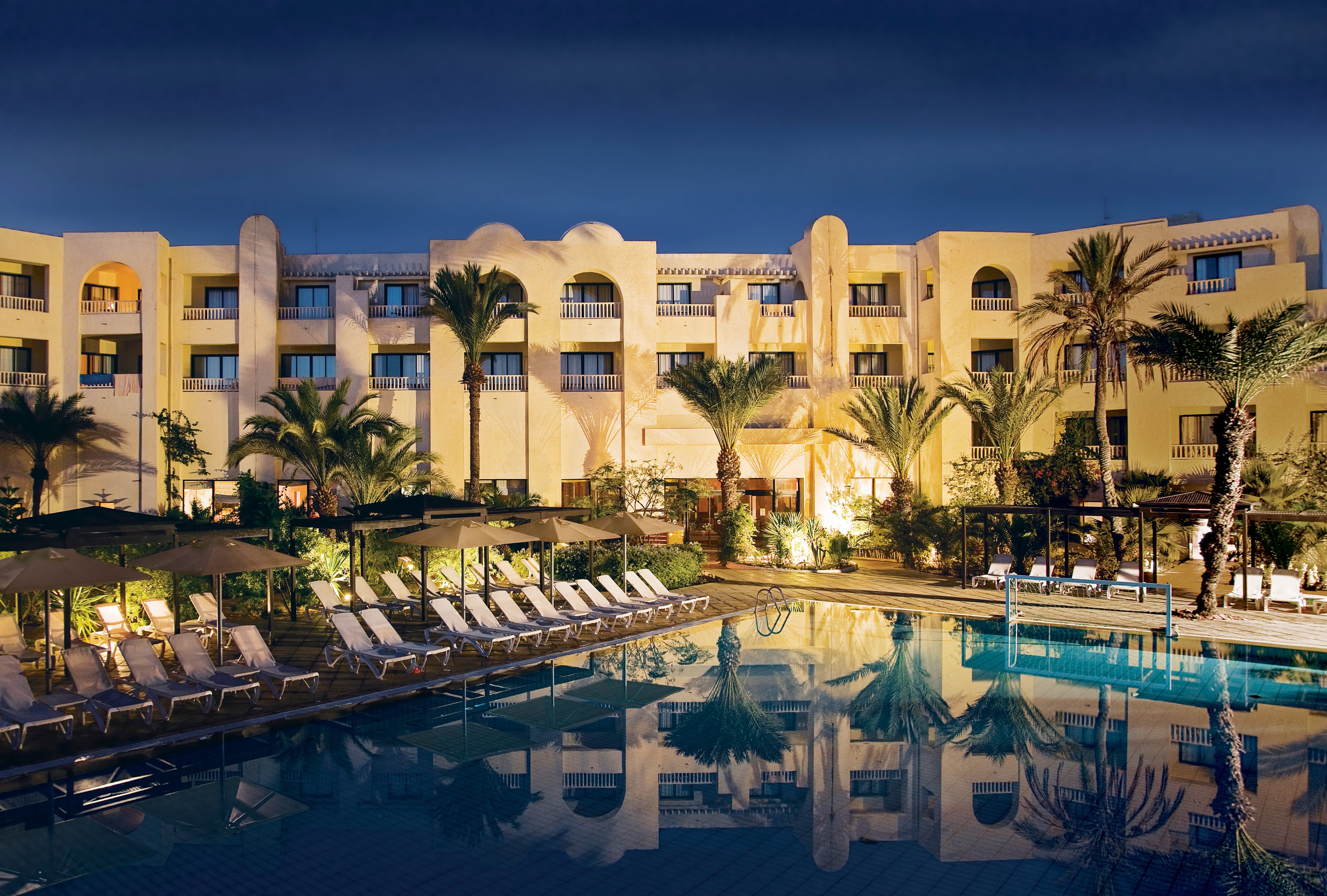 Luxuriöser Hotelpool bei Sonnenuntergang, Palmen und gepflegte Anlagen, Premium Cluburlaub bei Aldiana