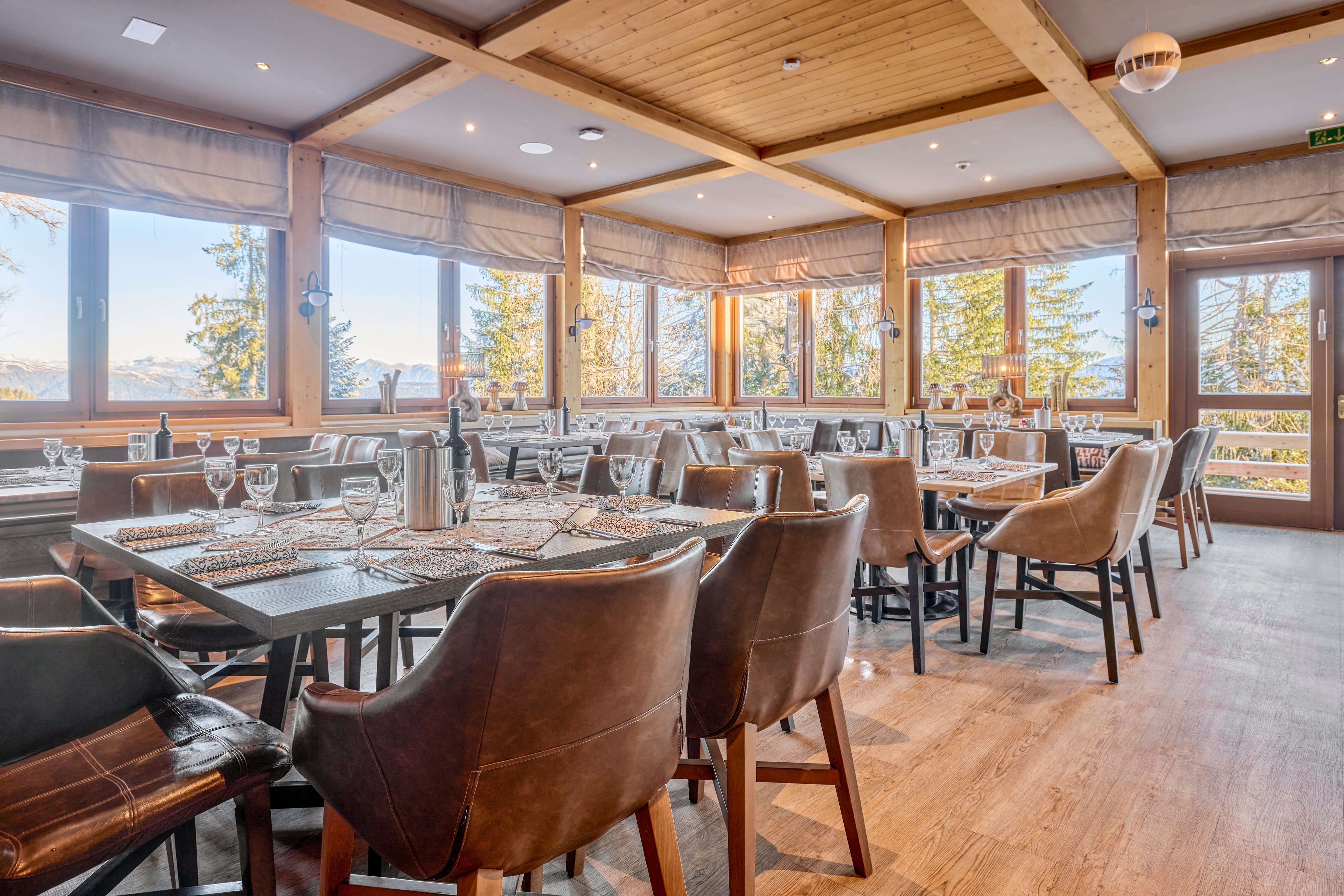 Innenraum eines eleganten Restaurants bei Aldiana mit Tischen, Stühlen und großem Fensterblick