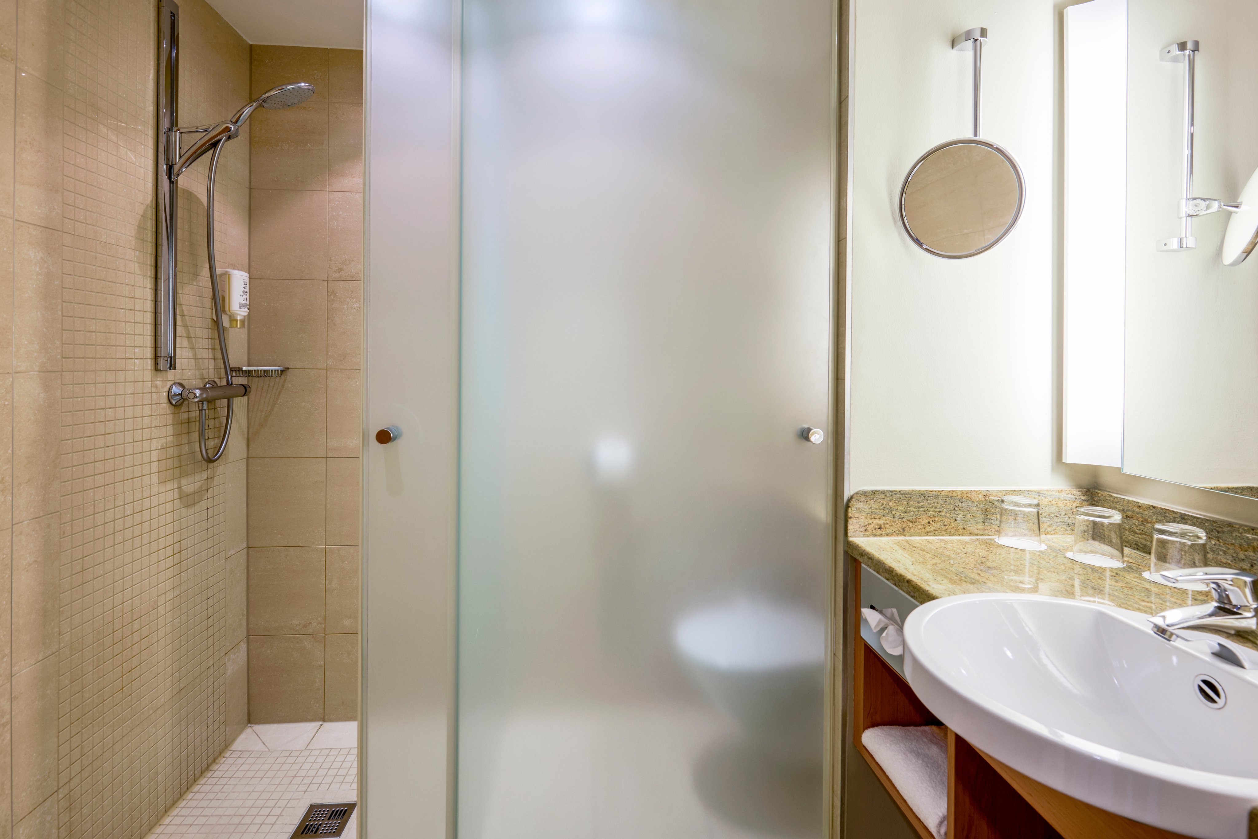 Badezimmer mit Dusche Waschbecken und großem Spiegel im Premium Cluburlaub bei Aldiana