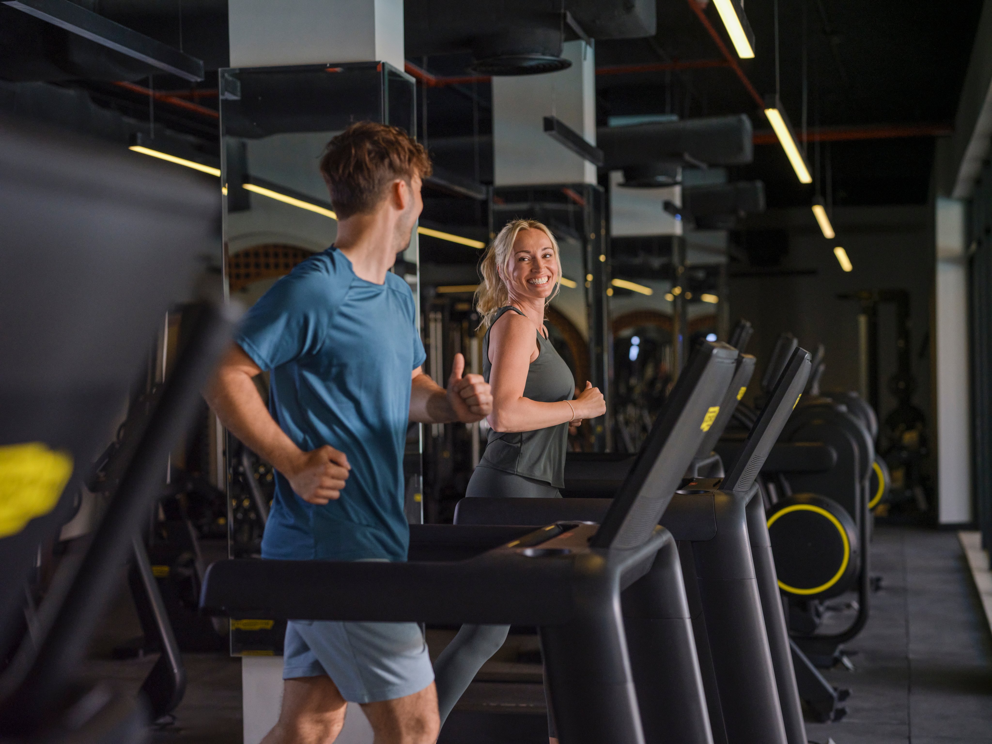 Menschen laufen auf Laufbändern im modernen Fitnessstudio bei Aldiana Premium Cluburlaub