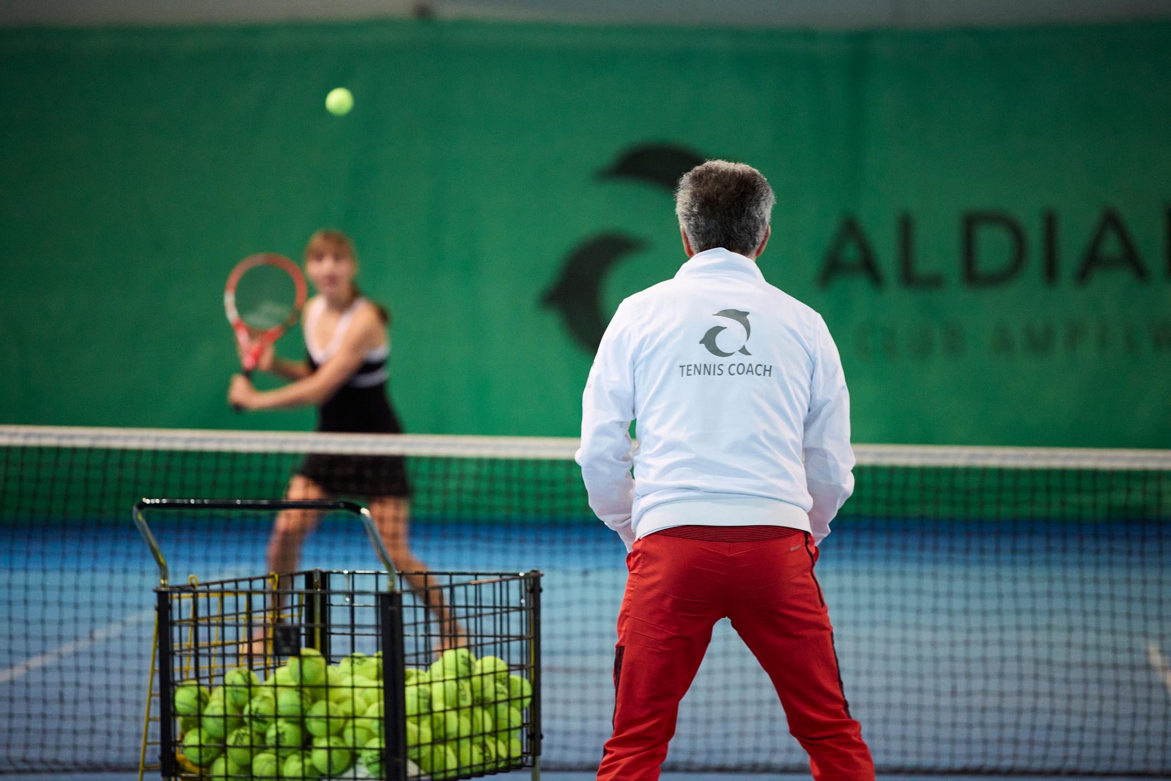Trainer beobachtet Tennisübungen auf einem Premium Cluburlaub Sportplatz bei Aldiana