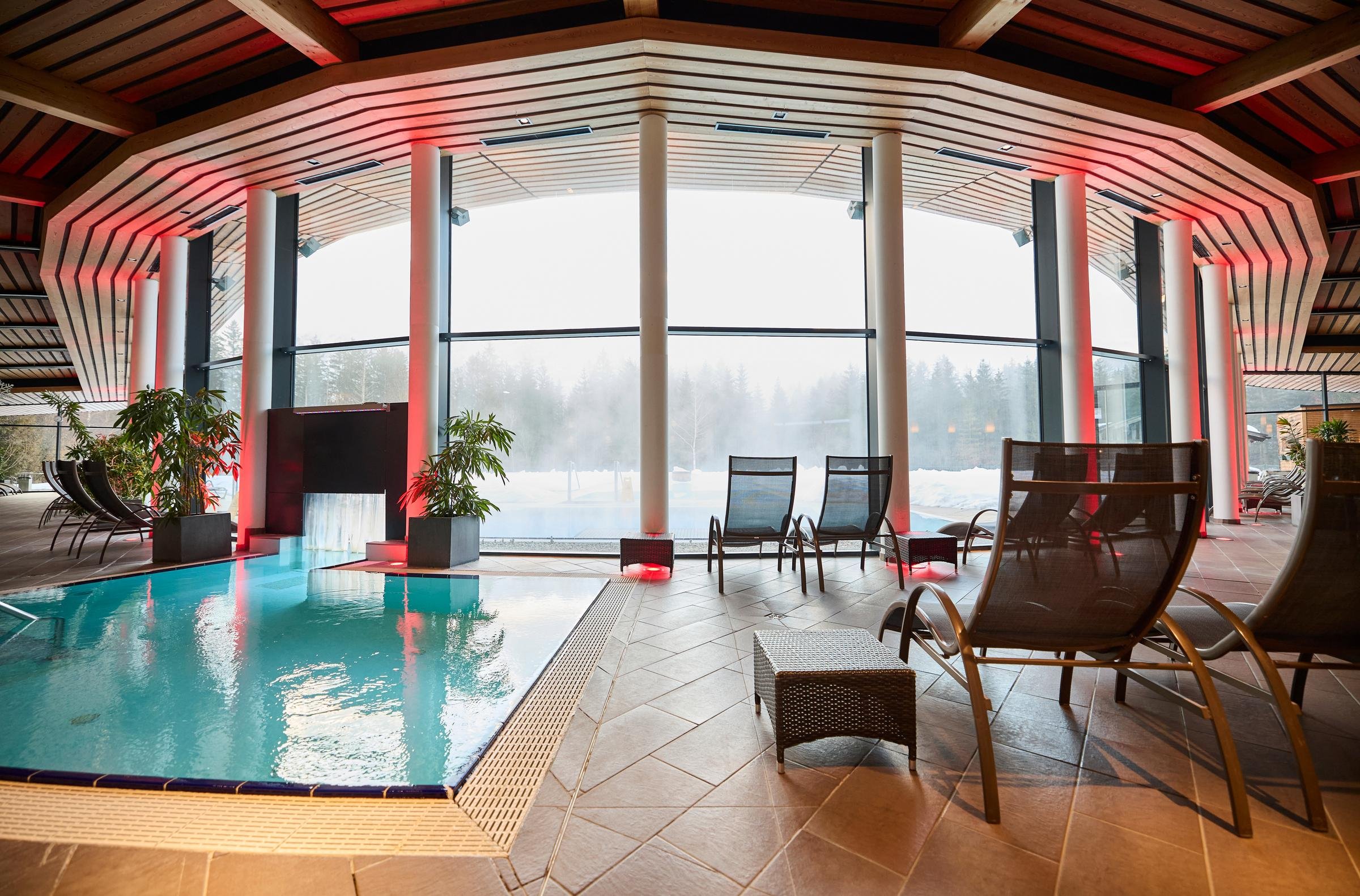 Innenaufnahme eines Luxushotels mit Pool und großen Fenstern für einen Premium Cluburlaub