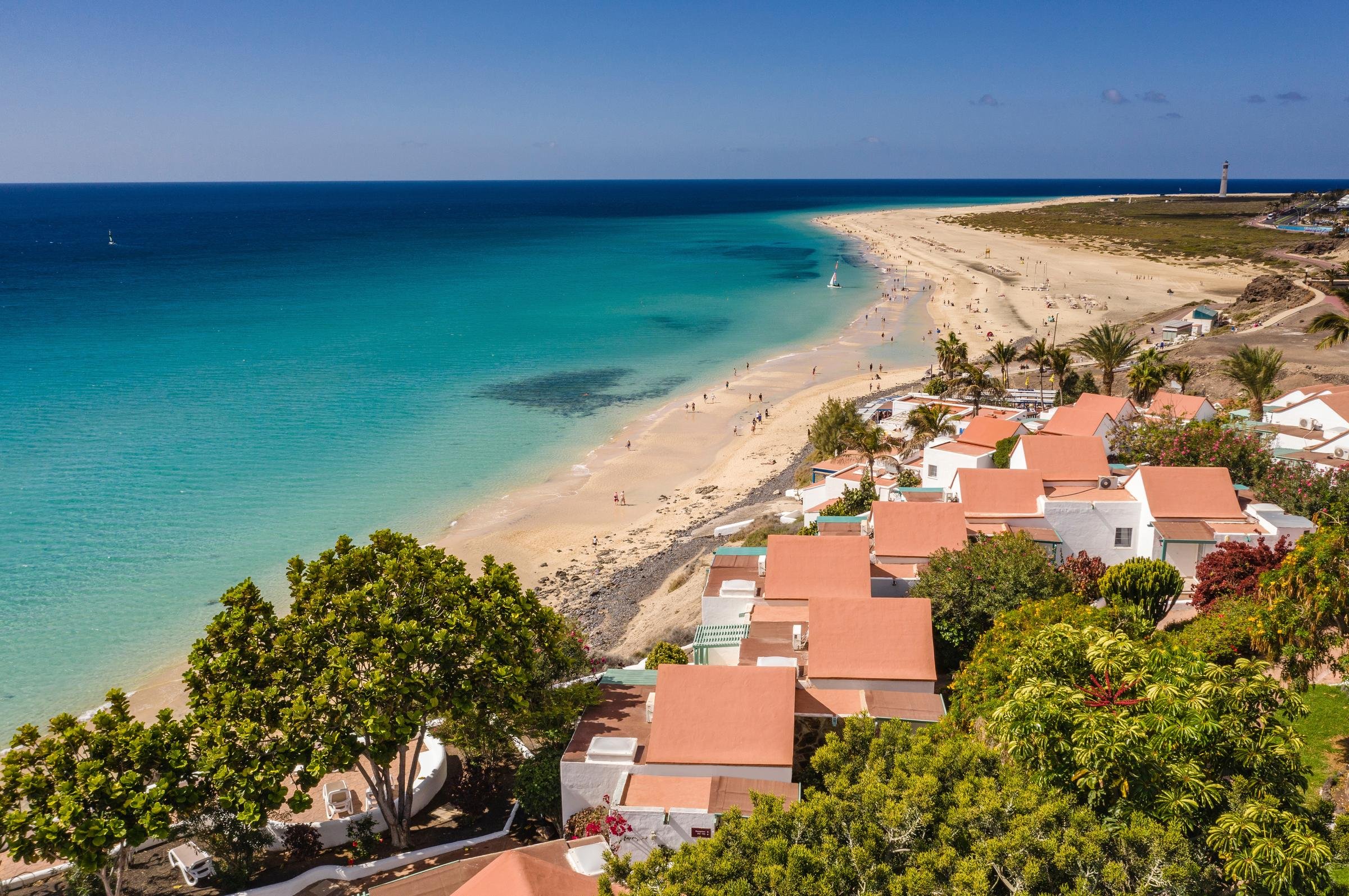 Aldiana Hotel am Strand mit Pool, Sonne, Palmen und türkisfarbenem Wasser.