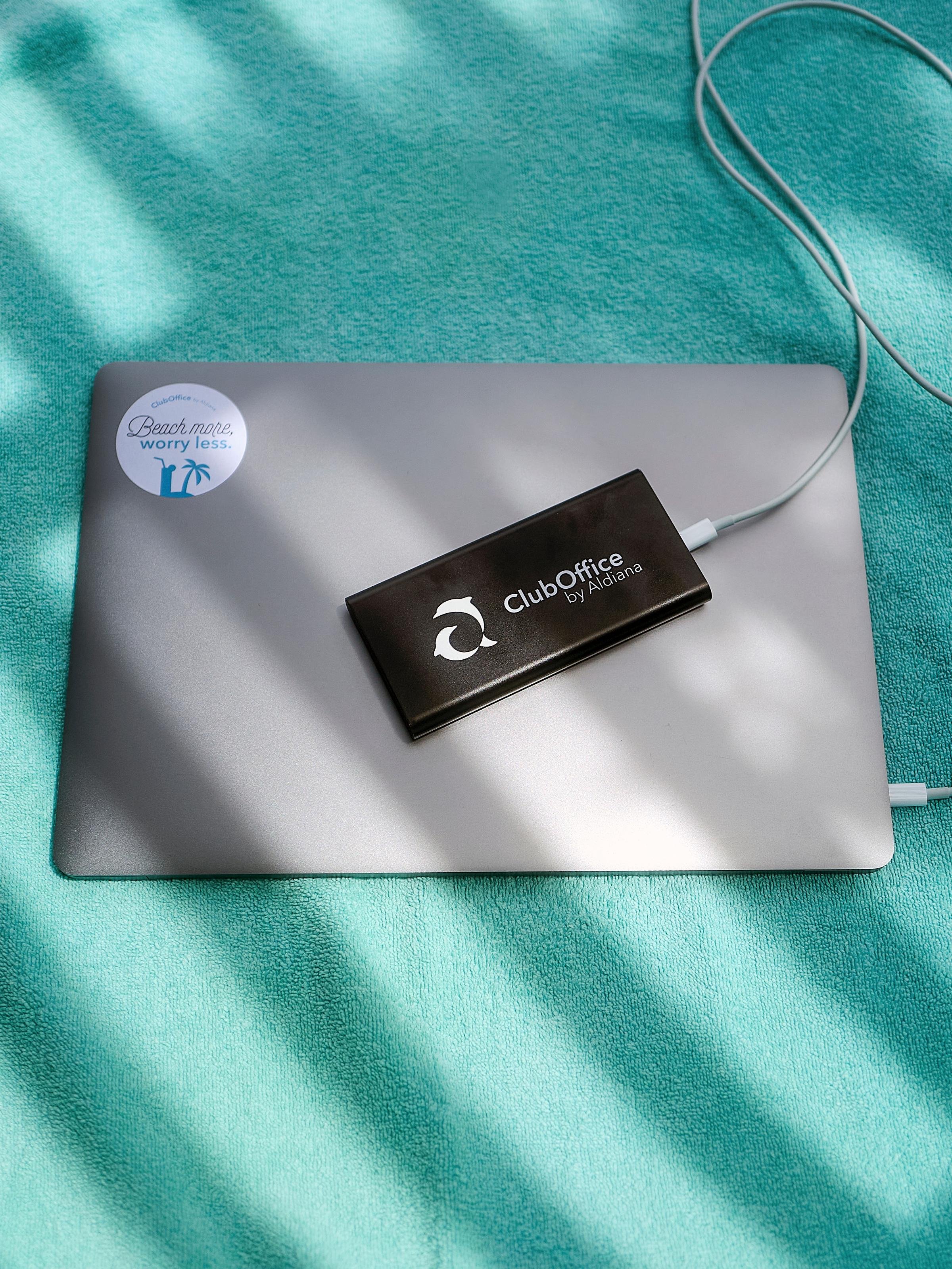 Laptop mit ClubOffice Logo auf einer Unterlage, sonniges Licht, entspanntes Ambiente