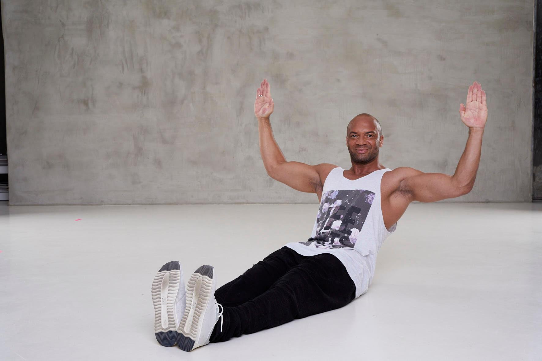 Mann dehnt sich im modernen Fitnessraum bei Aldiana, Premium Cluburlaub, sportlich aktiv