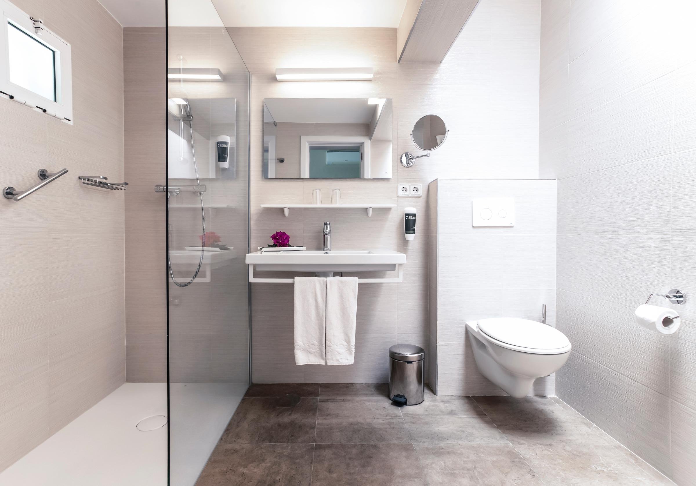 Ein modernes Badezimmer mit begehbarer Dusche, Waschbecken und Toilette im Premium Cluburlaub von Aldiana