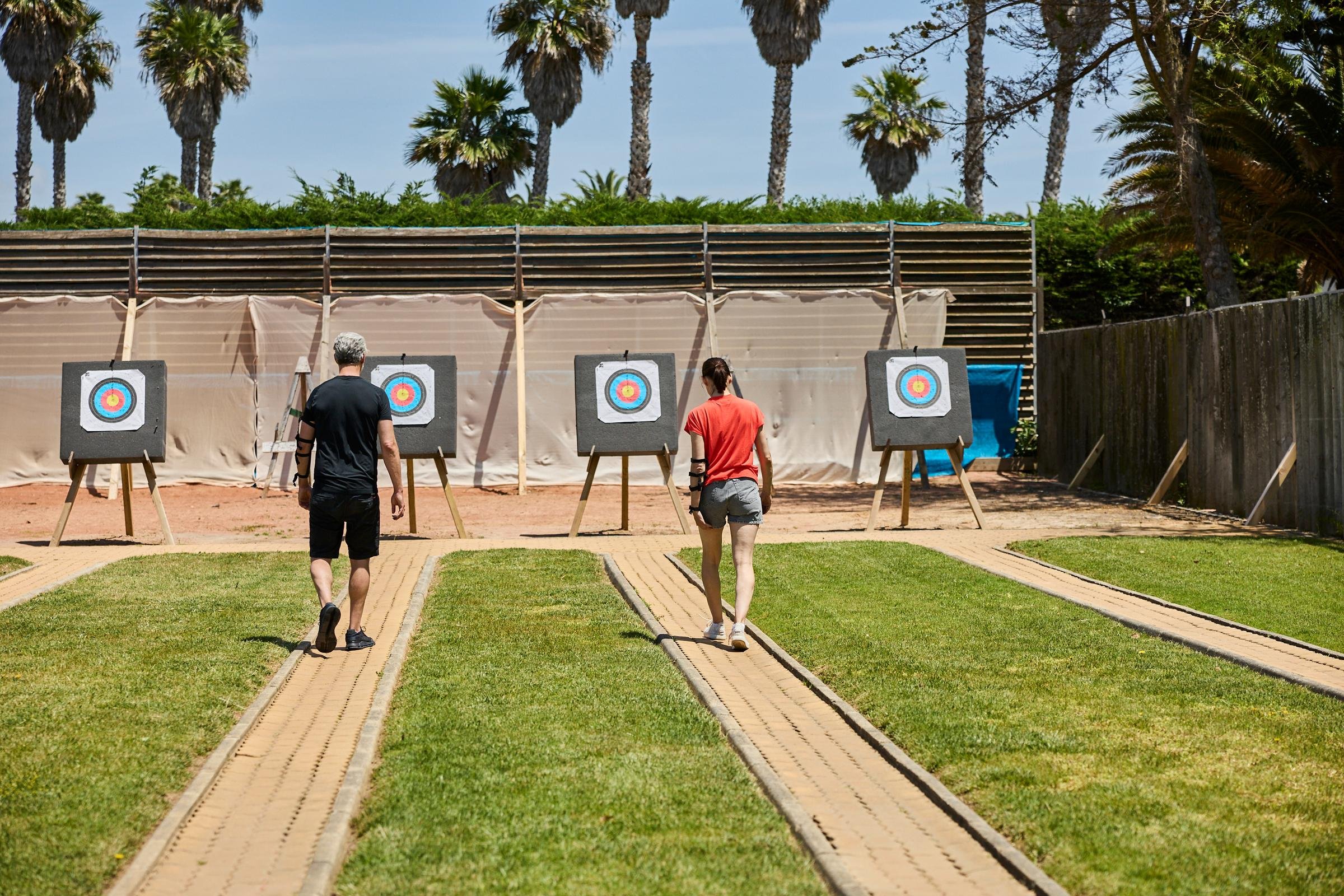 Vier Personen beim Bogenschießen auf einem Rasenplatz bei Aldiana Premium Cluburlaub