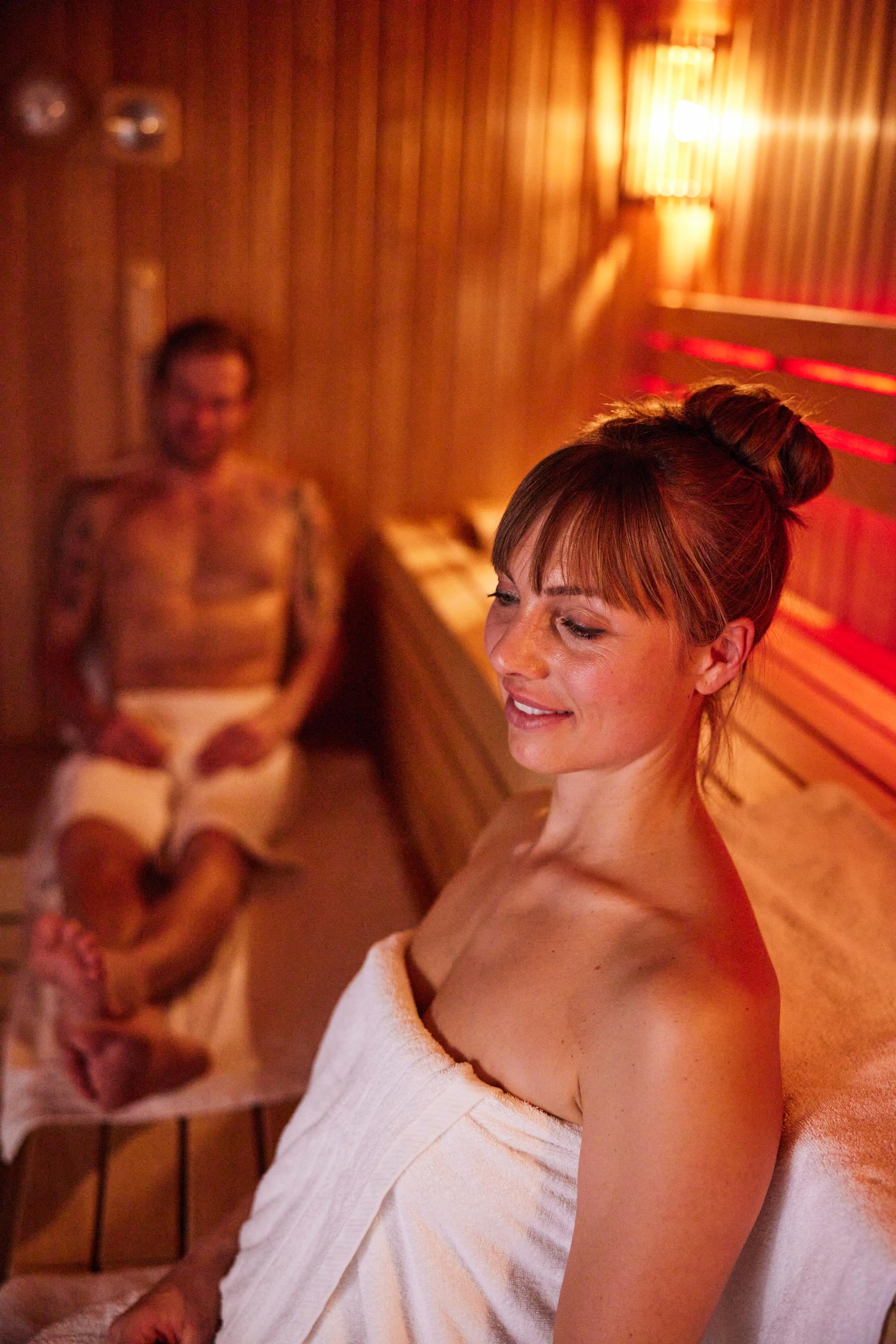 Menschen entspannen sich in einem komfortablen, eleganten Aldiana Clubraum bei warmem Licht