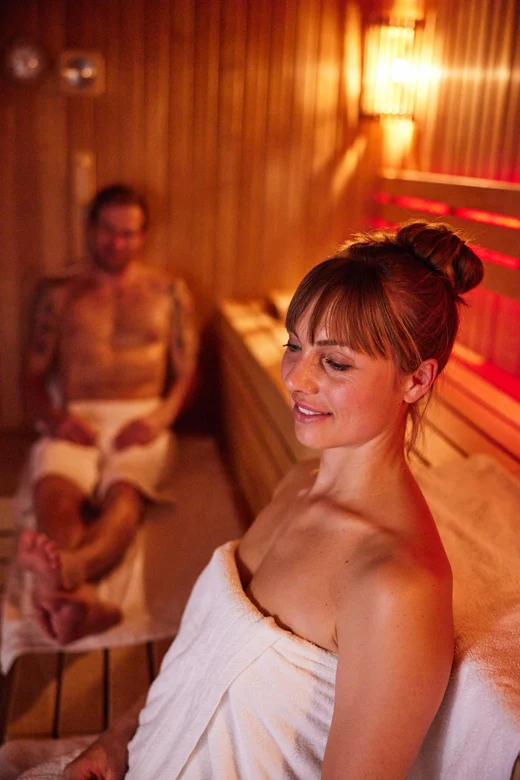 Menschen entspannen sich in einem komfortablen, eleganten Aldiana Clubraum bei warmem Licht