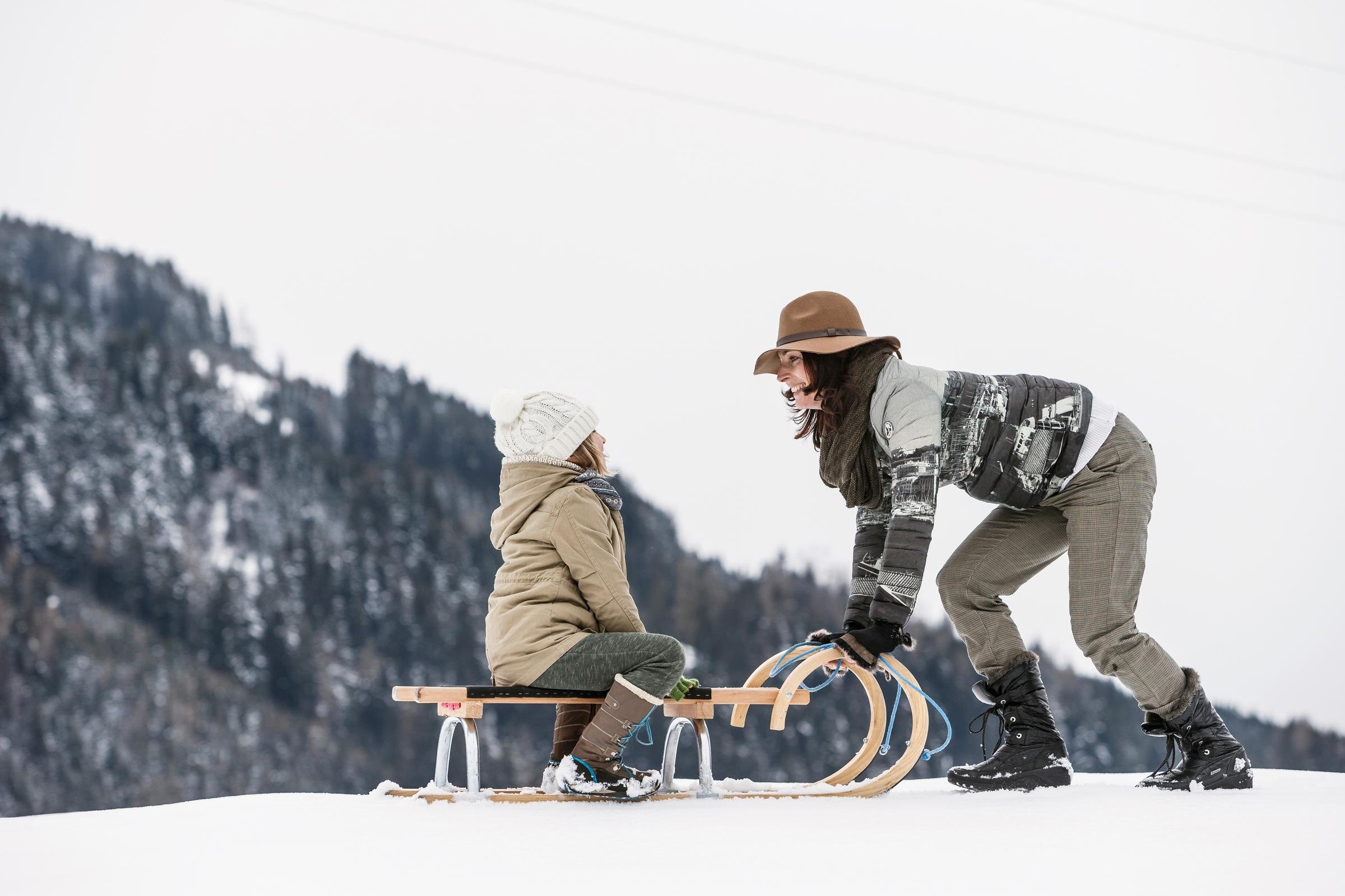 Kinder beim Schlittenfahren im Schnee, Winterlandschaft, hochwertiger Premium Cluburlaub bei Aldiana