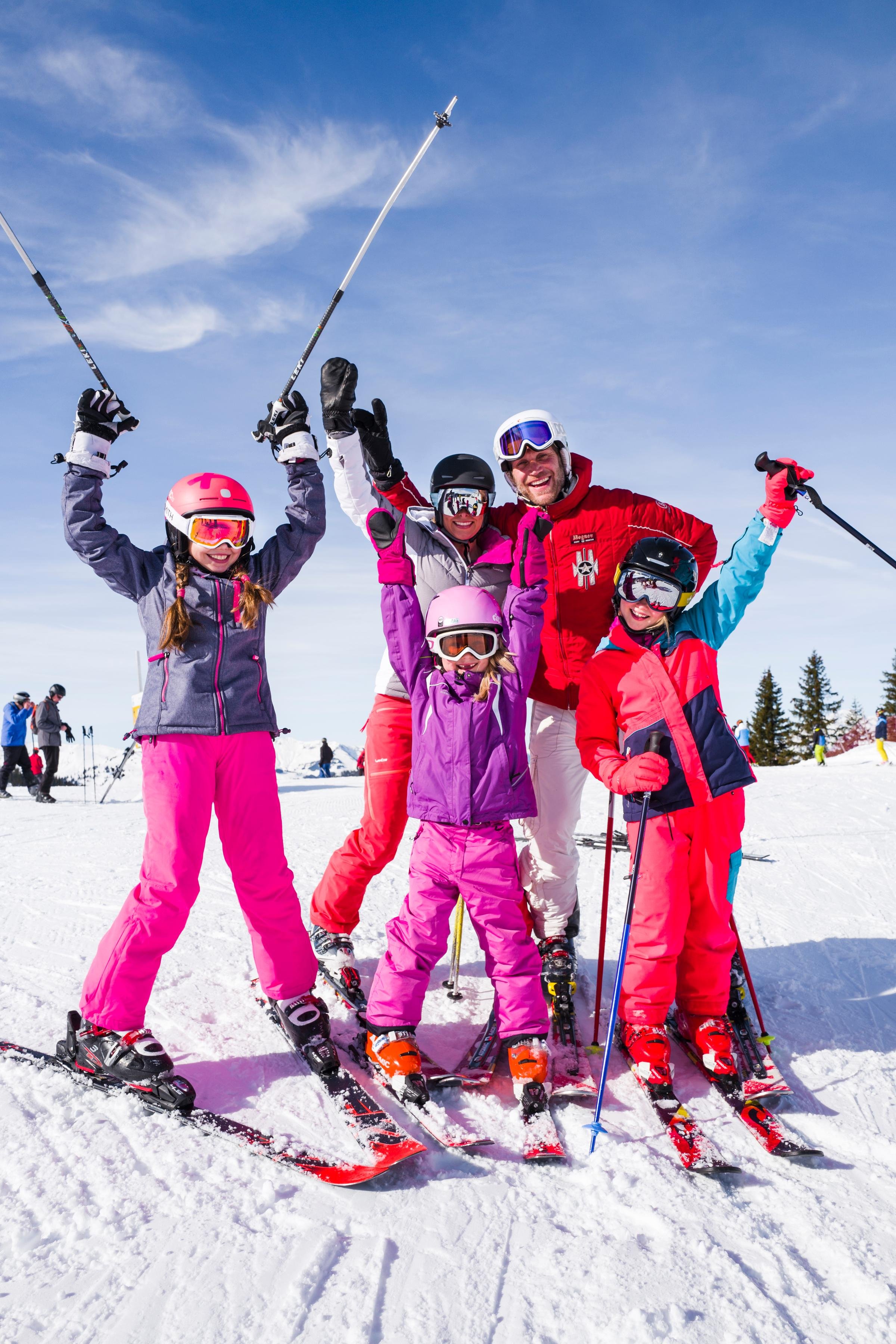 Familien beim Skifahren im Schnee, fröhlich und aktiv im Winterurlaub bei Aldiana