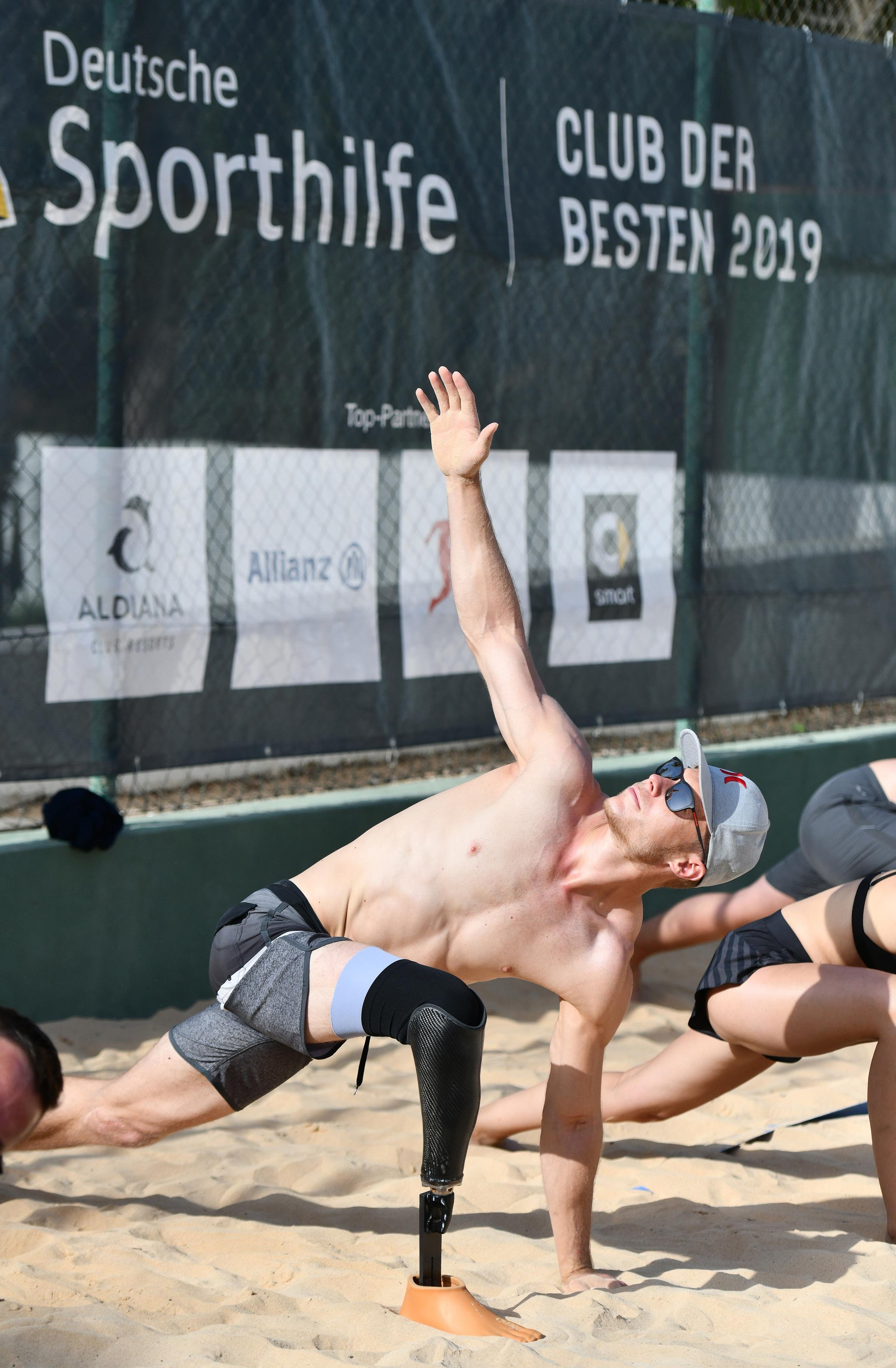 Ein männlicher Beachvolleyballspieler mit Prothese beim Sprung am Sandplatz bei Aldiana
