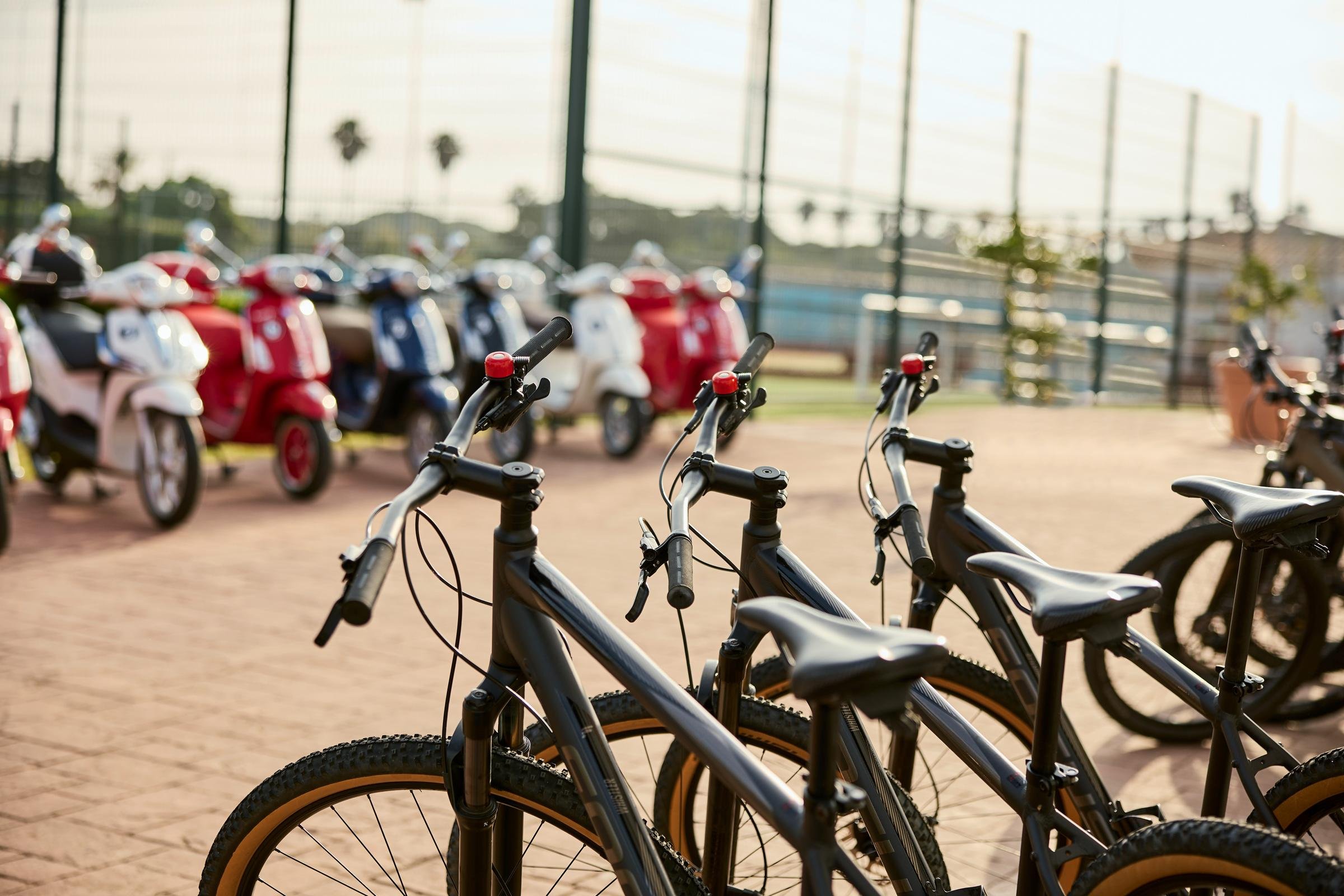 Bürgersteig mit Fahrradständern und bunten Motorrollern auf einem gepflasterten Platz