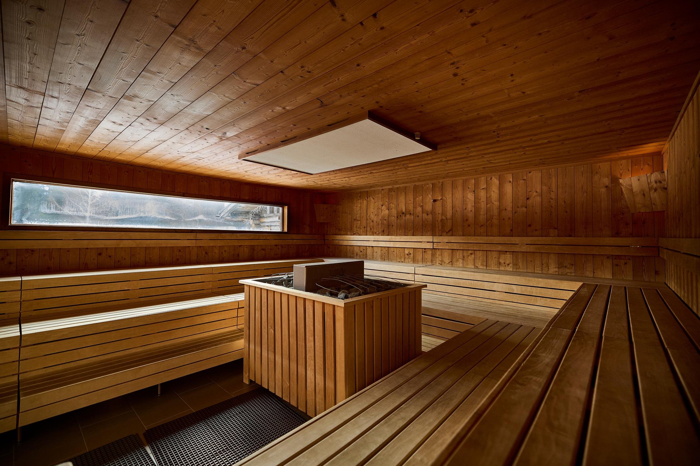 Innenraum eines luxuriösen warmen Saunabereichs mit Holzsaunen und natürlichem Licht