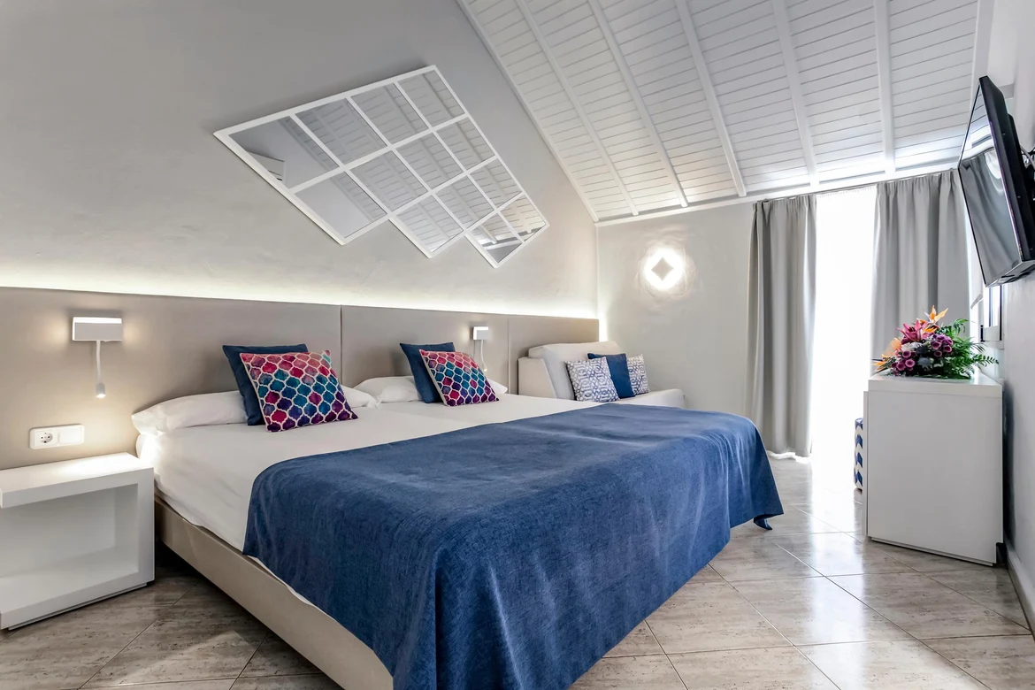 Moderne Hotelzimmer mit Doppelbett, TV, Fenster und dekorativer Dekoration, komfortabel.