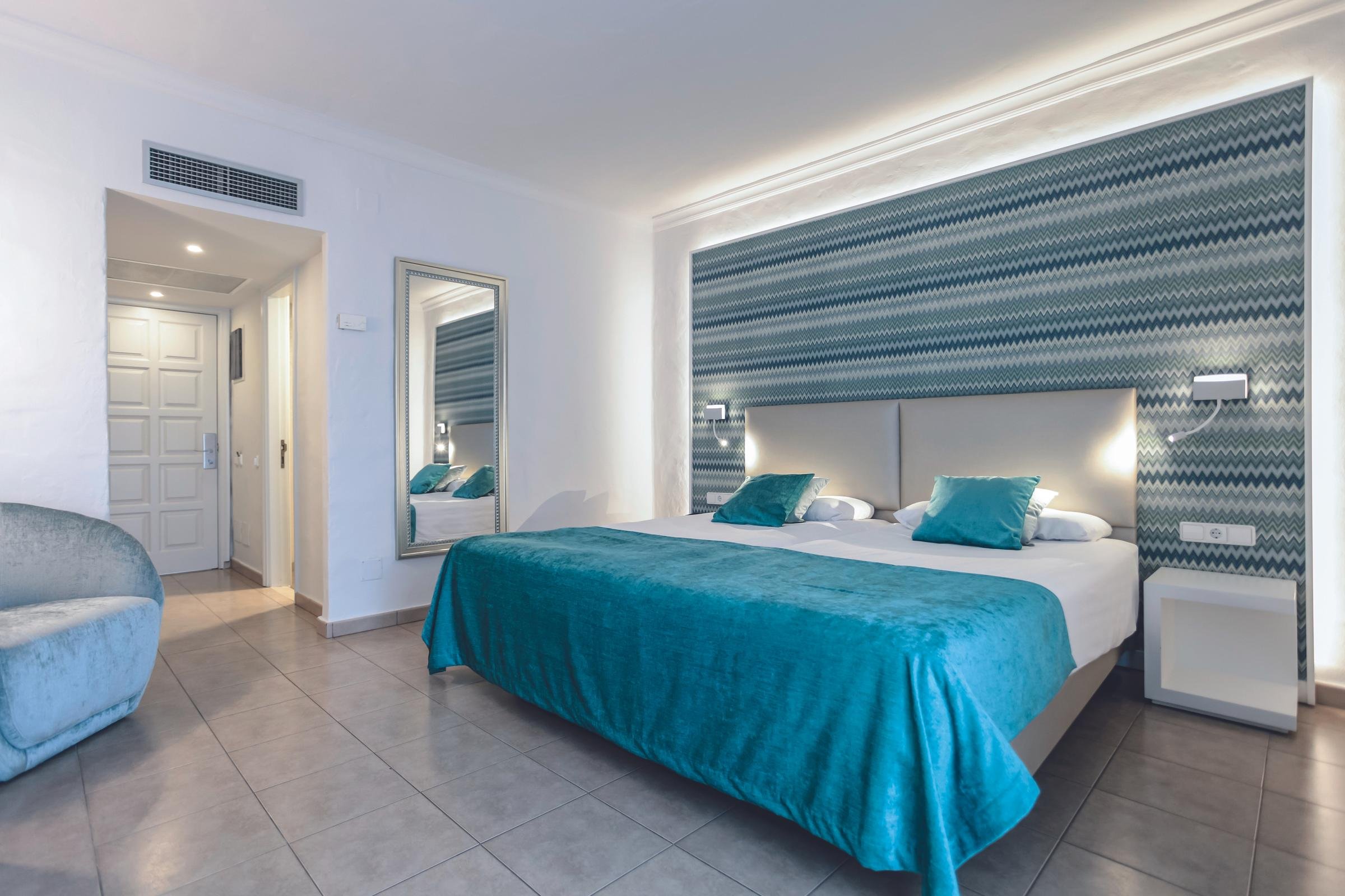 Modernes Hotelzimmer bei Aldiana mit gemütlichem Bett und stilvoller Einrichtung.