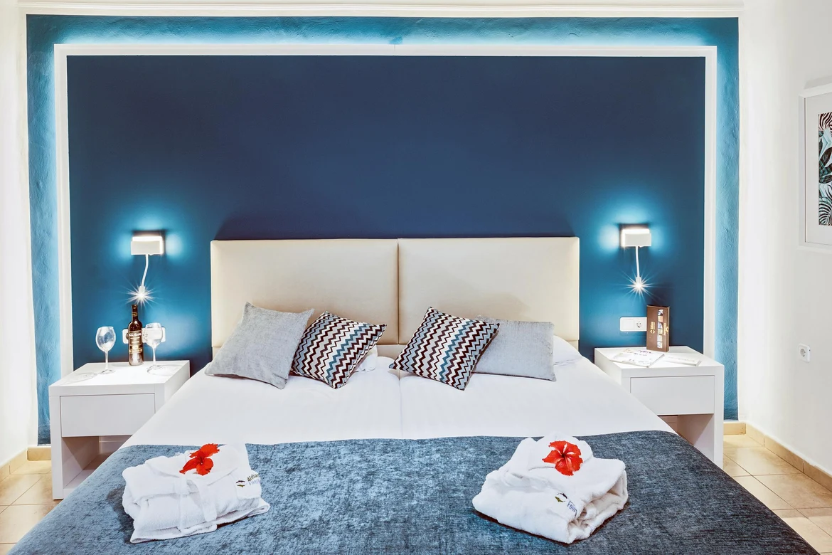 Elegantes Hotelzimmer mit Doppelbett, Nachttischen,atschluss, gemütlichen Kissen und Beleuchtung