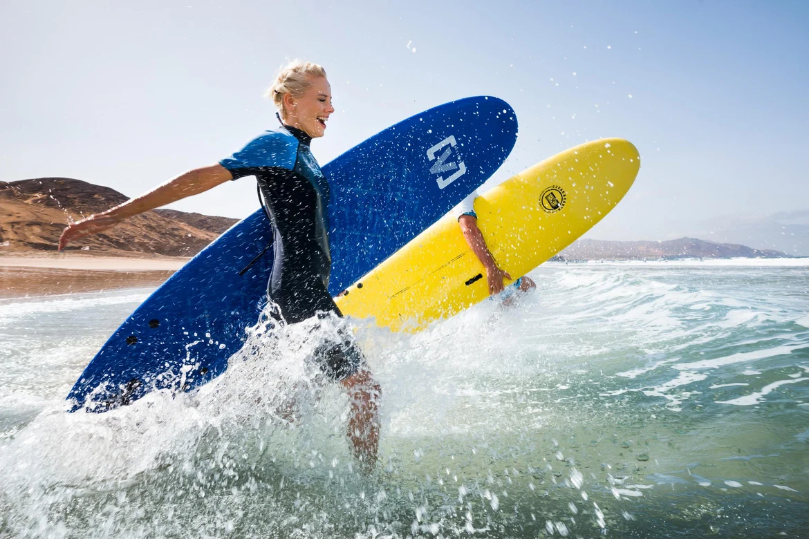 Ableitende Person beim Surfen am Meer, Freude und Aktivität, Premium Cluburlaub bei Aldiana