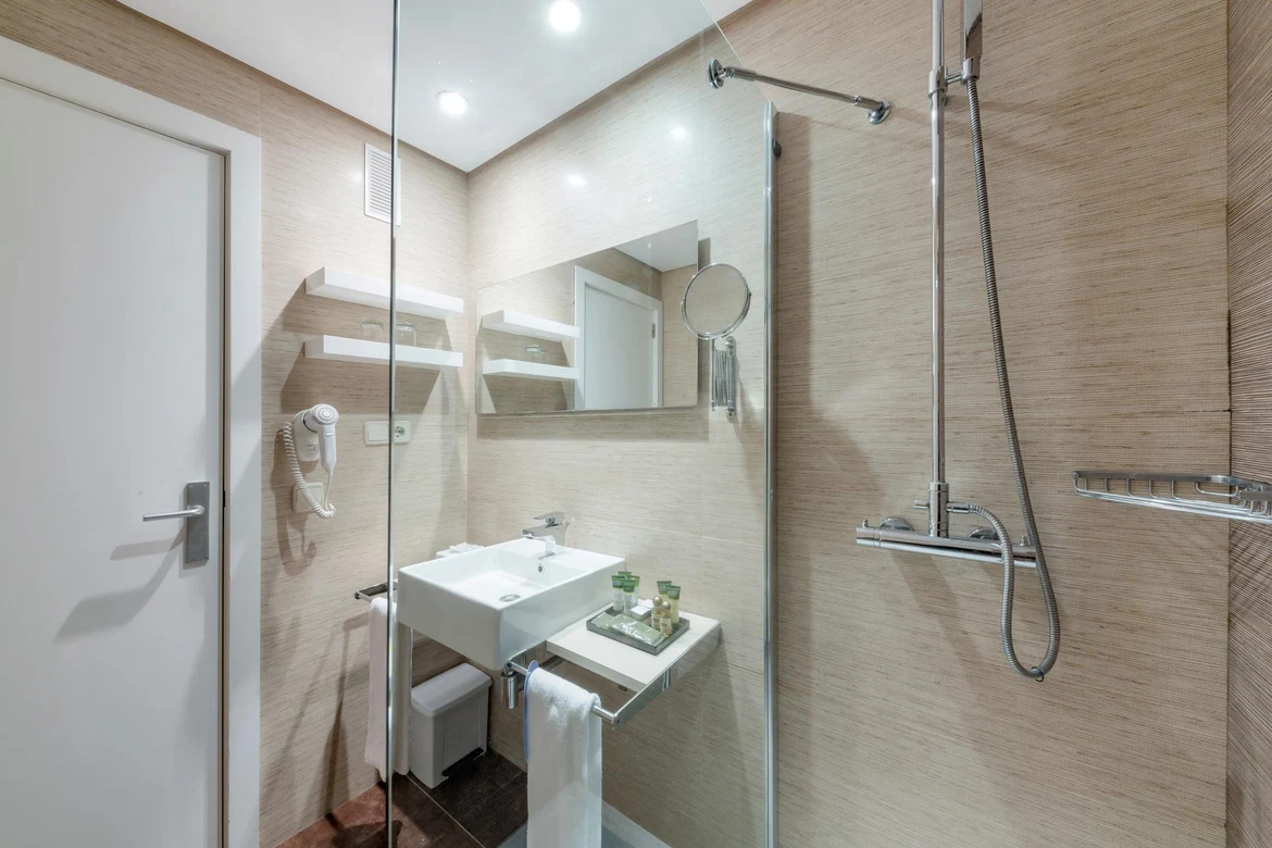 Modernes Badezimmer mit Spiegel, Waschbecken und Duschbereich in einem Aldiana Premium Cluburlaub