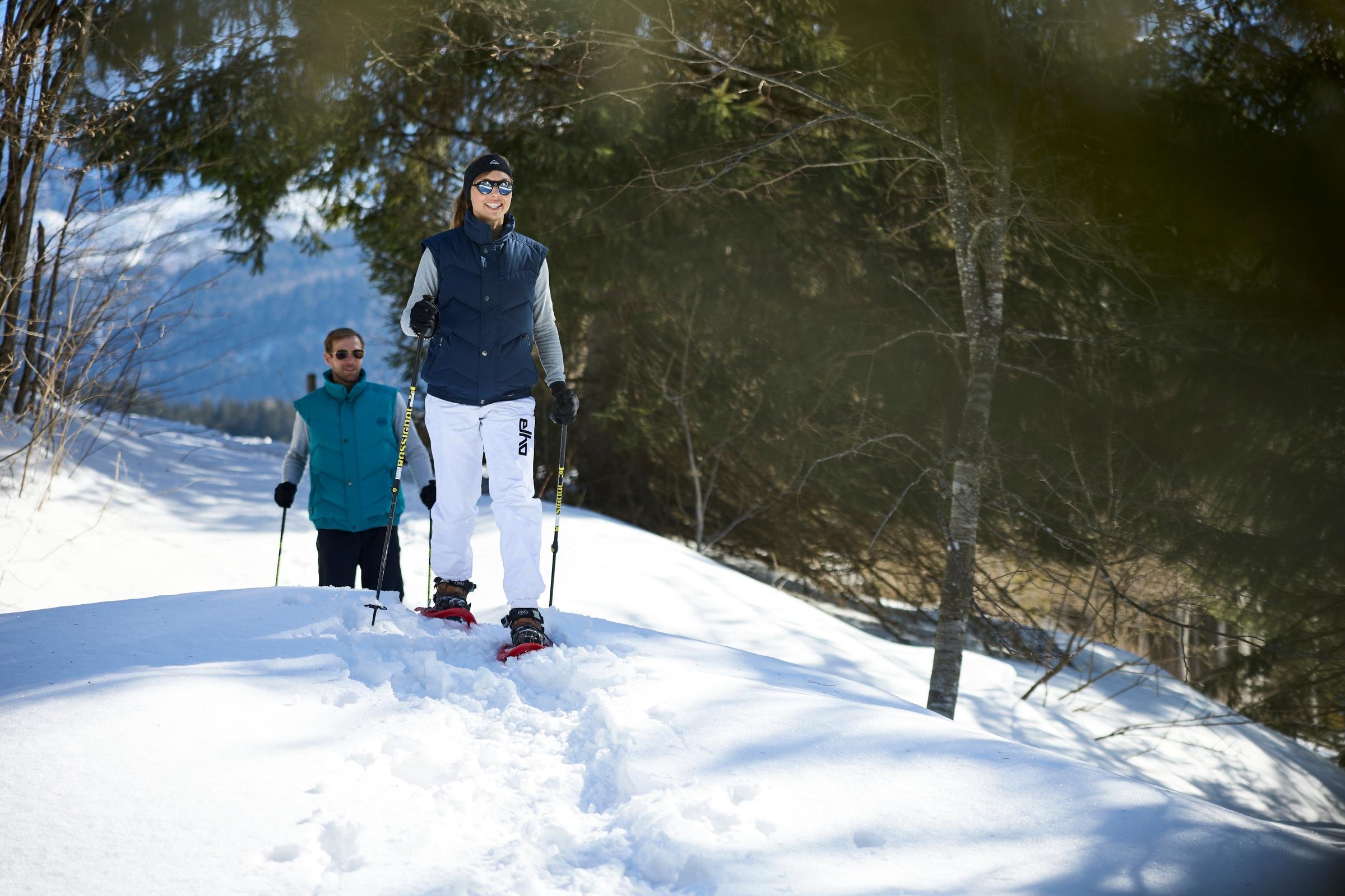 Zwei Skifahrer im winterlichen Wald, genießen einen Premium Cluburlaub bei Aldiana