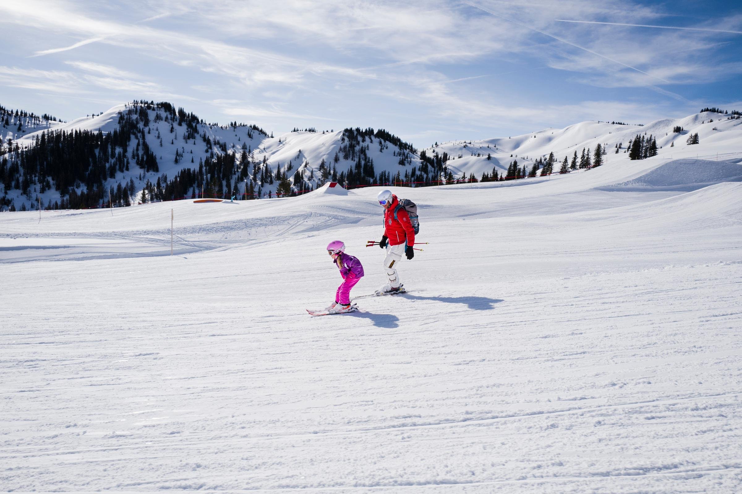 Kinder beim Skifahren im Schnee unter blauen Himmel bei einem Premium Cluburlaub von Aldiana