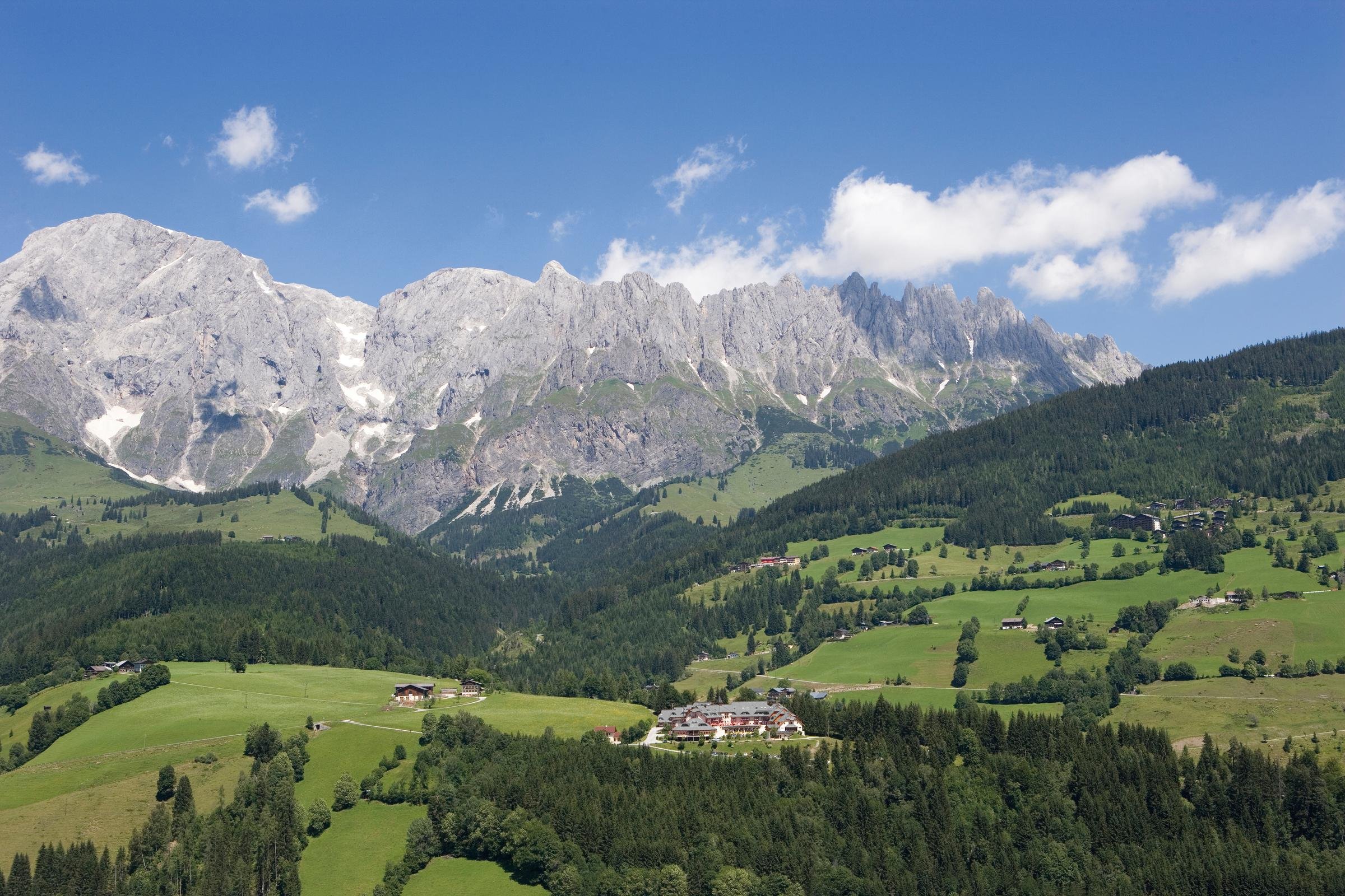 Ein grünes Hügelpanorama mit Bergen im Hintergrund, ideal für einen Premium Aldiana Cluburlaub