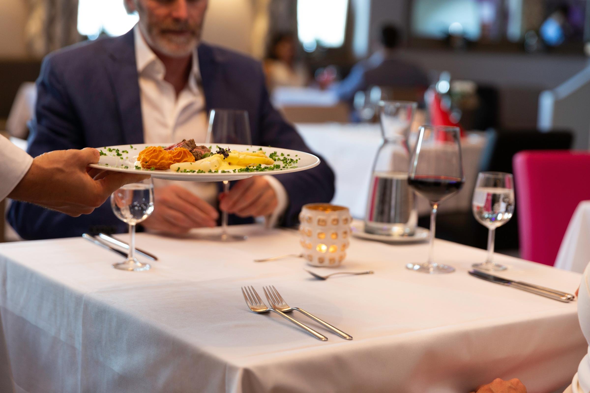 Elegantes Restaurant im Aldiana Premium Cluburlaub mit gedecktem Tisch, Weingläsern und Essen