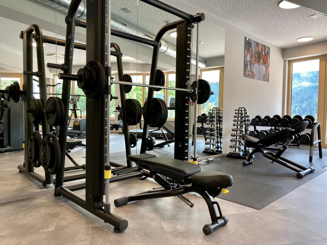 Fitnessstudio mit TechnoGym Geräten und Blick auf die Berge 
