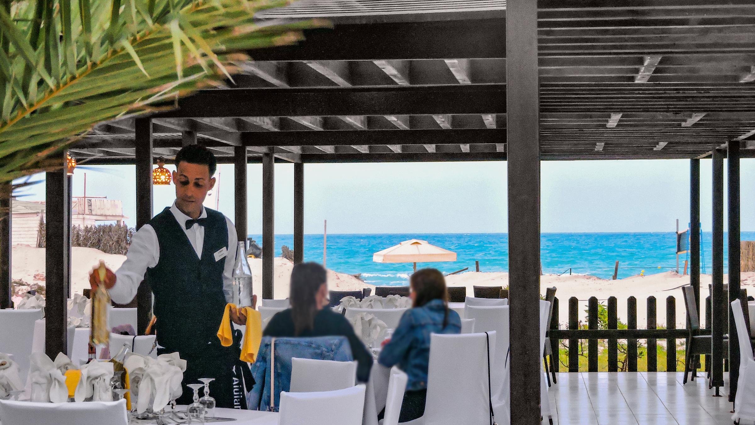 Outdoor Restaurant bei Aldiana mit Gästen und einem Kellner im Premium Cluburlaub