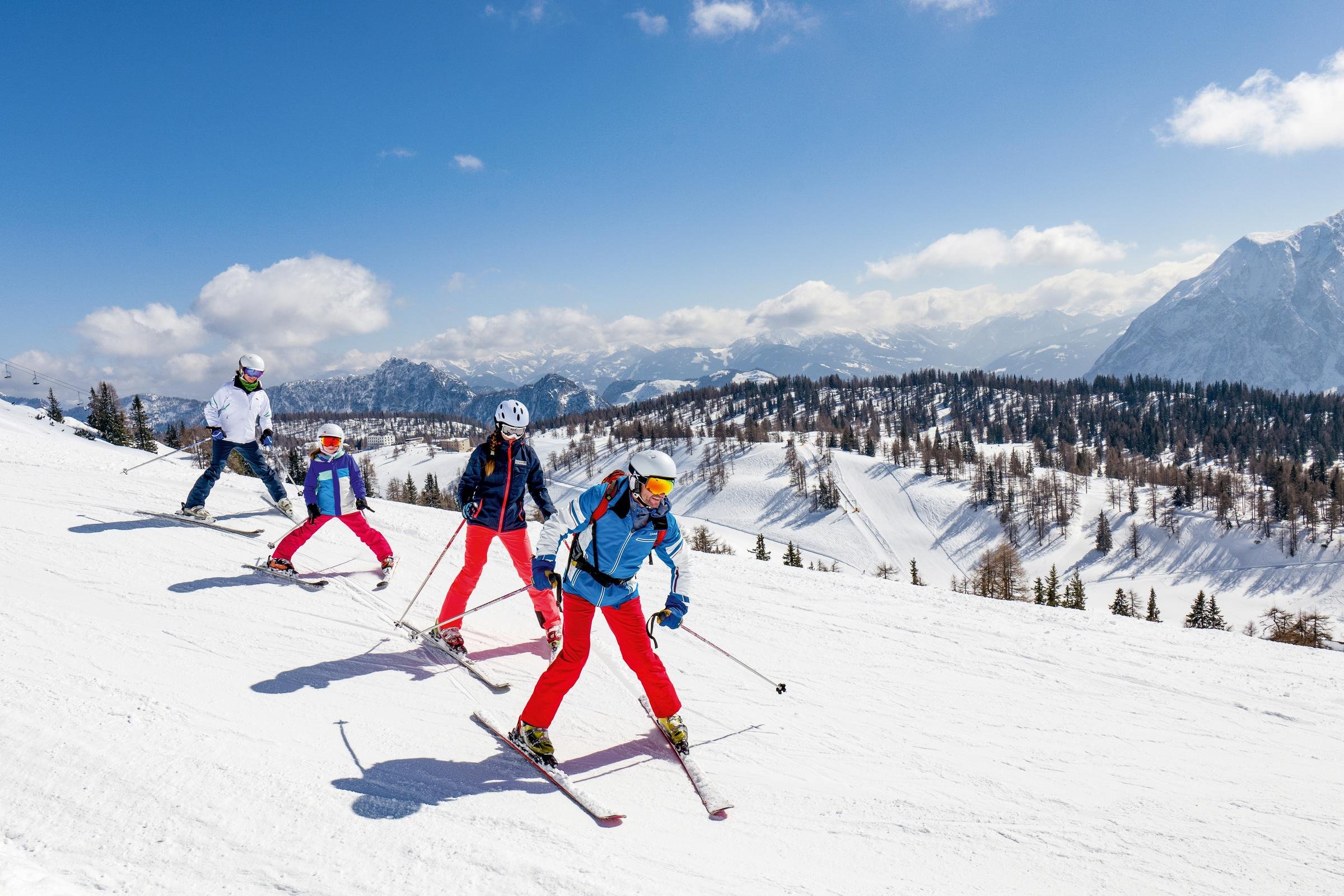 Skifahrer auf Piste im Schnee mit Bergen im Hintergrund, Erlebnis im Premium Cluburlaub bei Aldiana