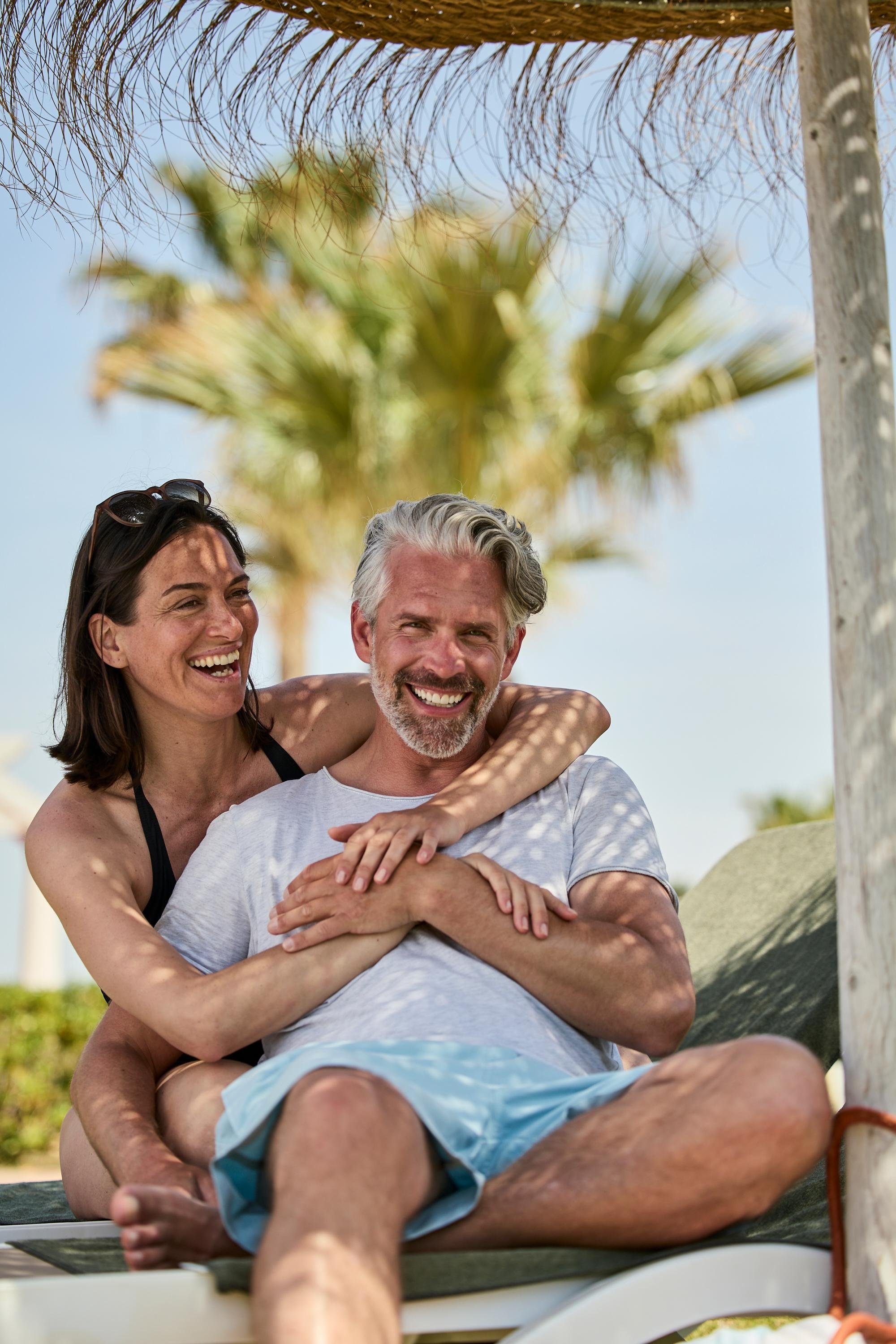 Paar entspannt am Strand bei Aldiana, Premium Cluburlaub im sonnigen Urlaubsparadies