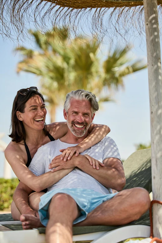 Paar entspannt am Strand bei Aldiana, Premium Cluburlaub im sonnigen Urlaubsparadies