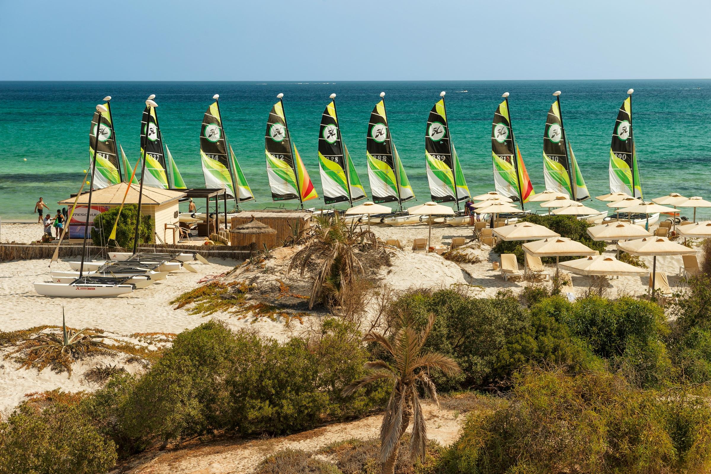 Strand mit Segelbooten und Sonnenschirmen bei Aldiana, Premium Cluburlaub an der Küste