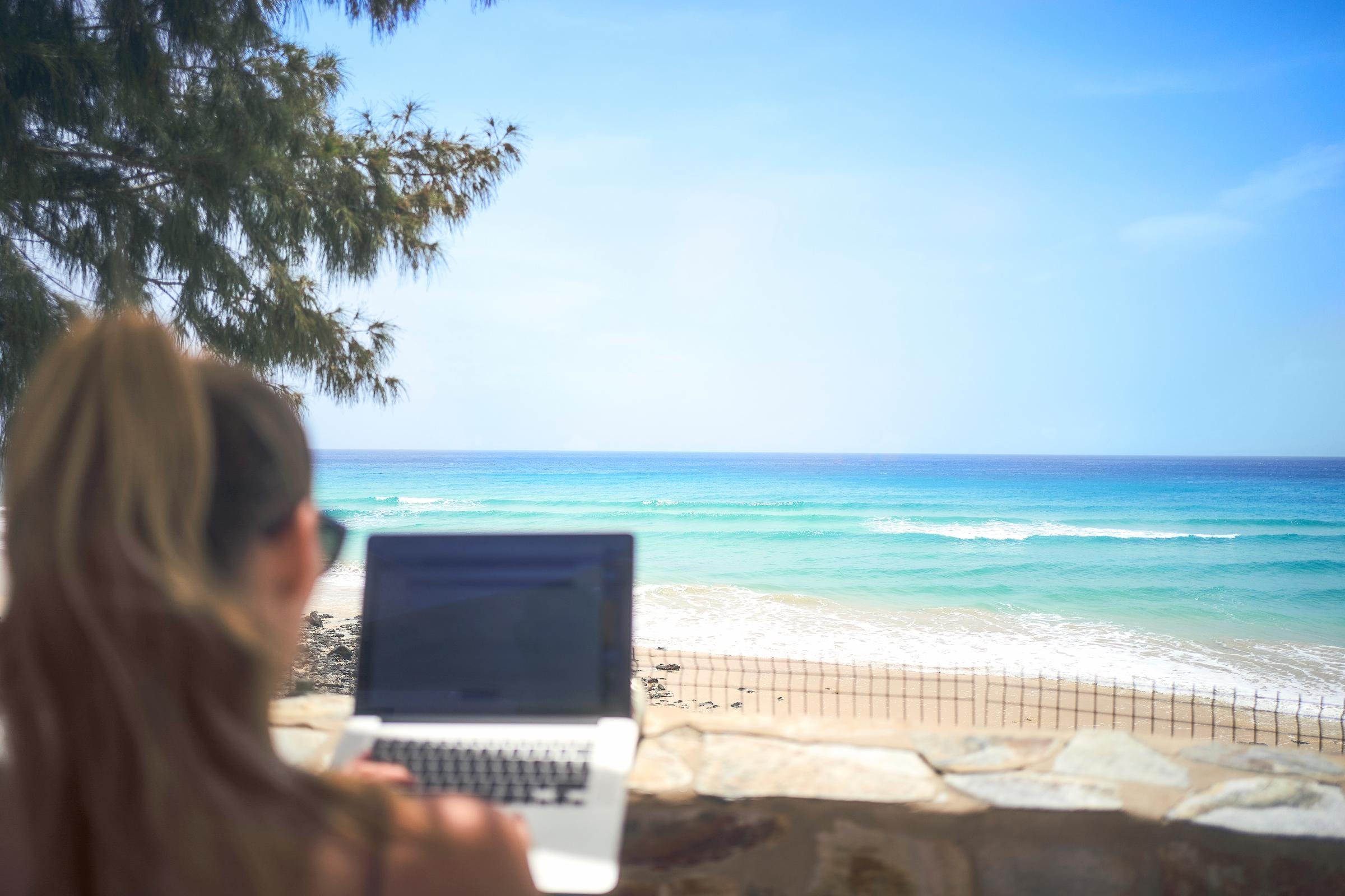 Frau mit Laptop am Strand bei Aldiana, Premium Cluburlaub, Meeresblick, Entspannung