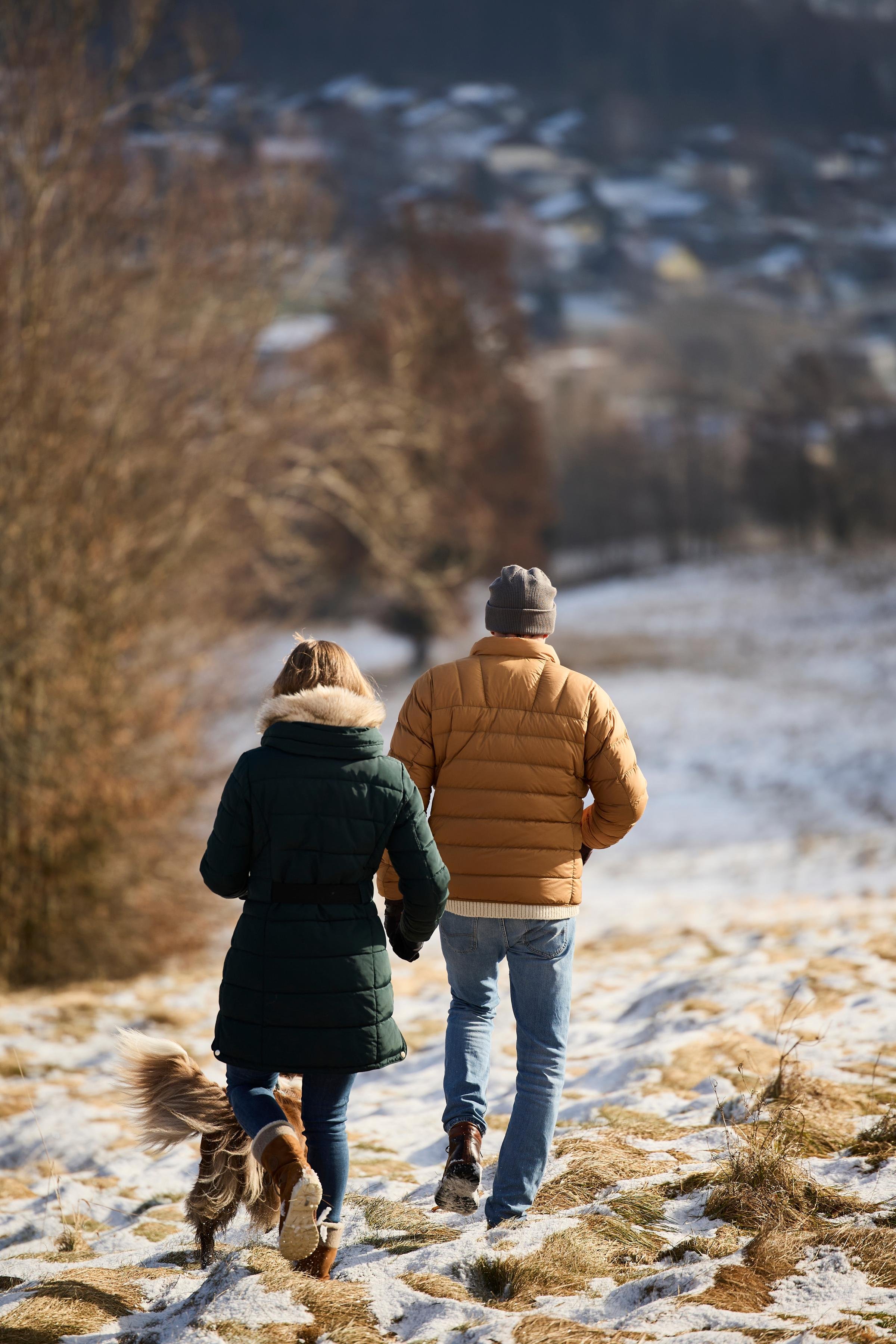 Zwei Personen gehen im Winter mit Hund in Natur, Premium Cluburlaub bei Aldiana