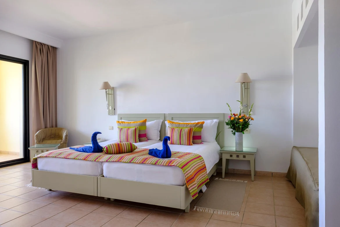 Schlafzimmer im Aldiana Premium Cluburlaub mit bequemem Bett, Kissen, Dekoration und Ausstattung