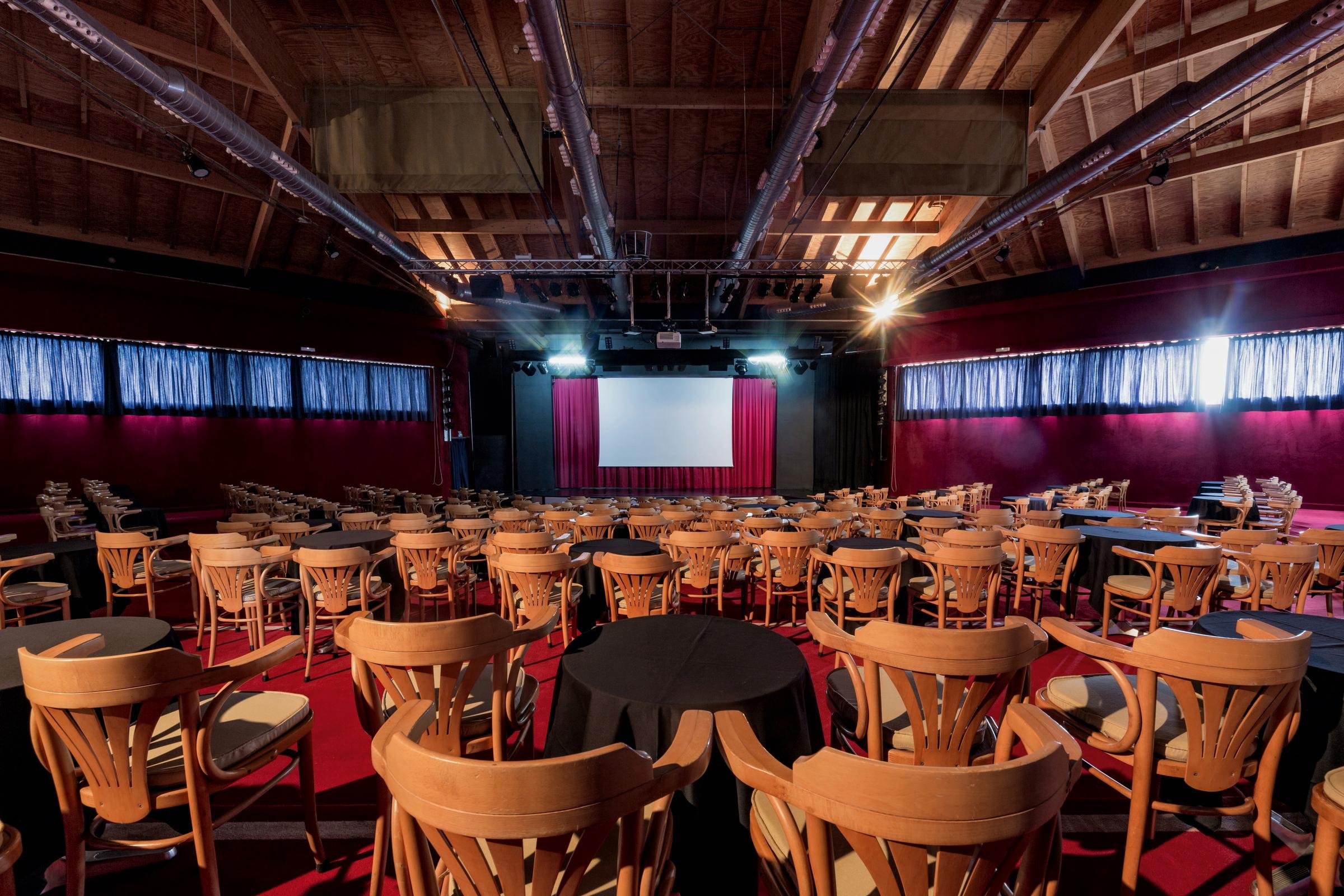 Ein Veranstaltungsraum mit Bühne, Stühlen und Leinwand für Premium Cluburlaub bei Aldiana