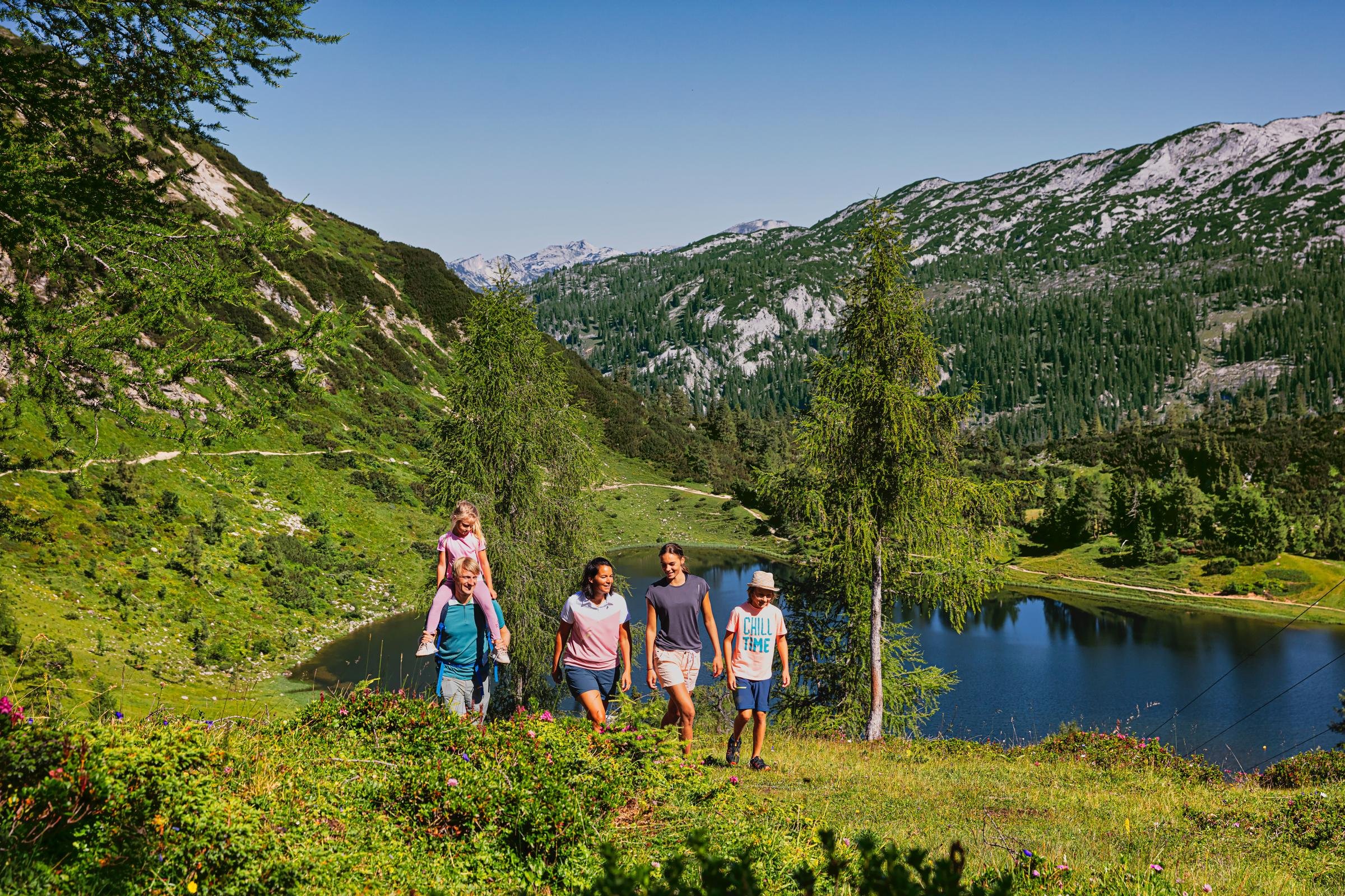 Familie wandert in der Natur an einem klaren See in den Bergen, Premium Cluburlaub bei Aldiana