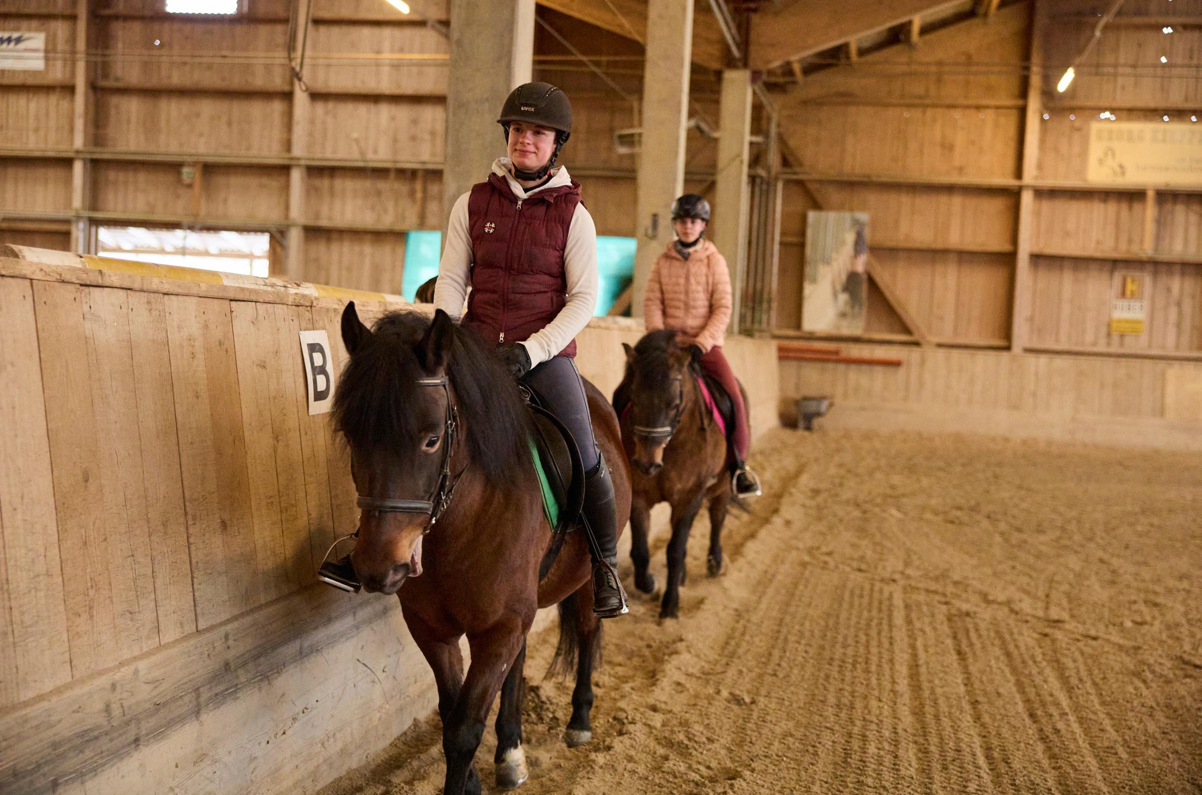 Jugendliche reiten in einem Indoor-Reitstall bei Aldiana, einem Anbieter für Premium Cluburlaub