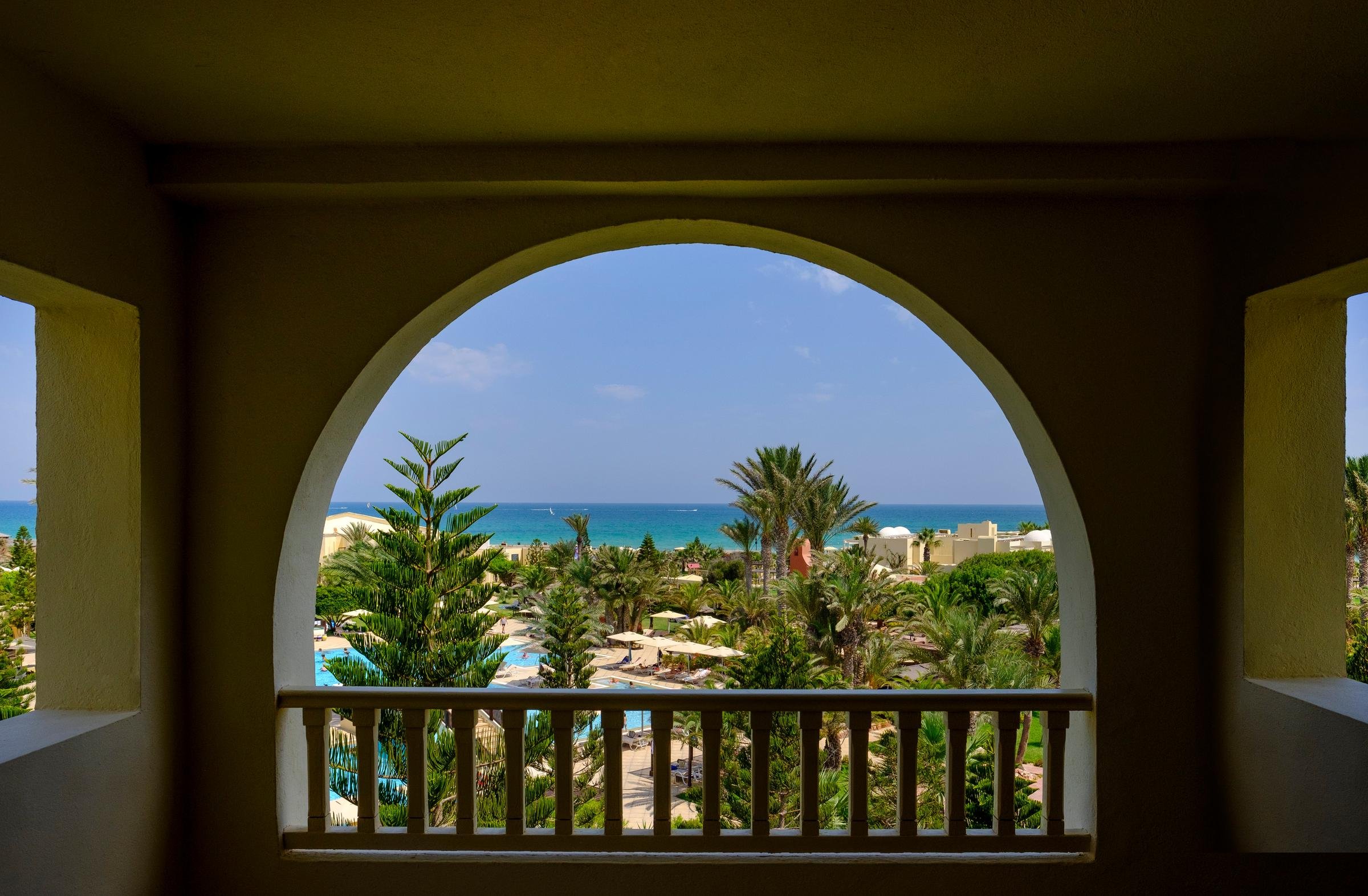 Blick auf den Strand und Palmen bei einem Premium Cluburlaub von Aldiana