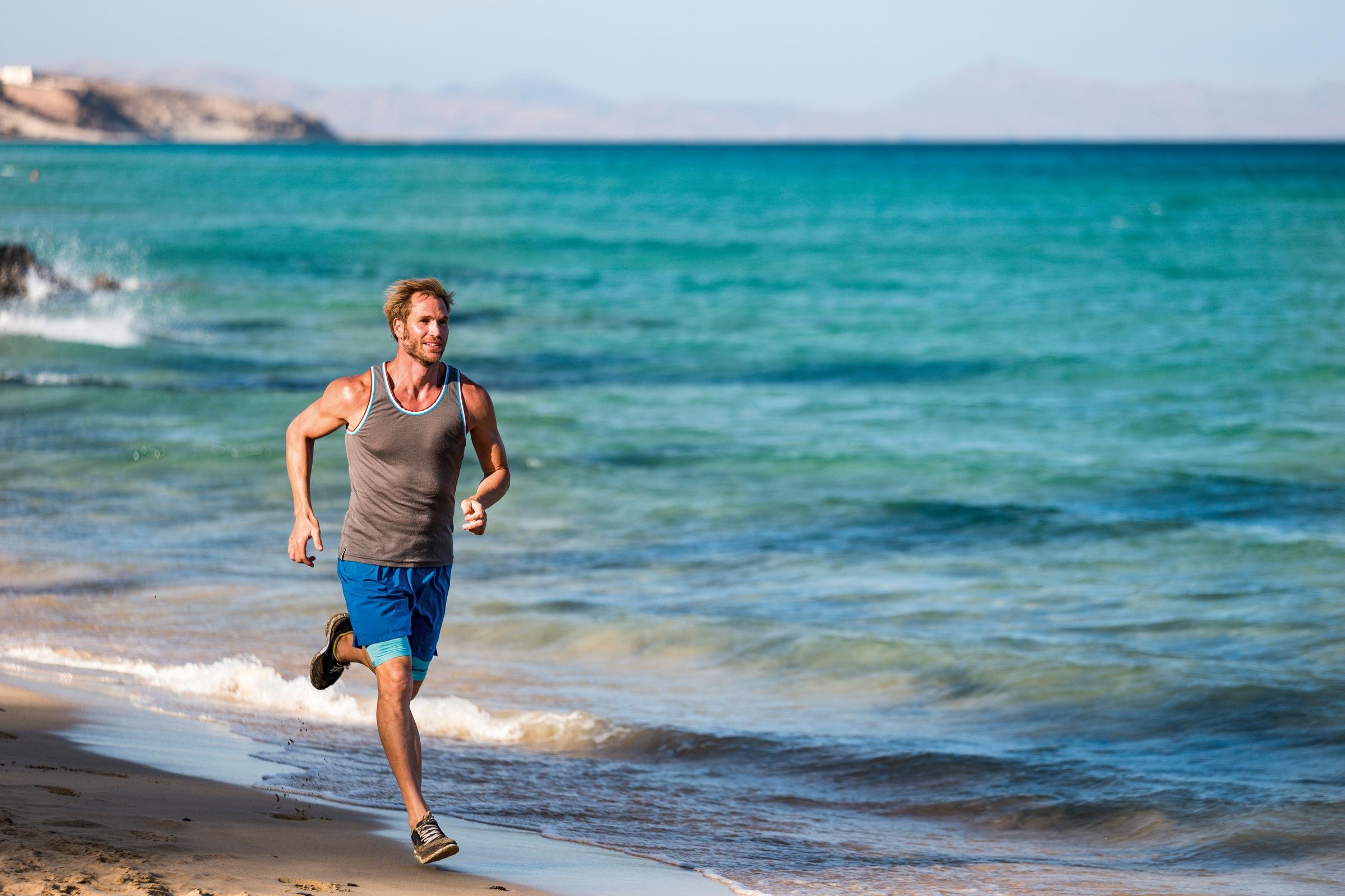 Jugendlicher läuft am Strand entlang bei Sonnenuntergang in einem Aldiana Premium Cluburlaub