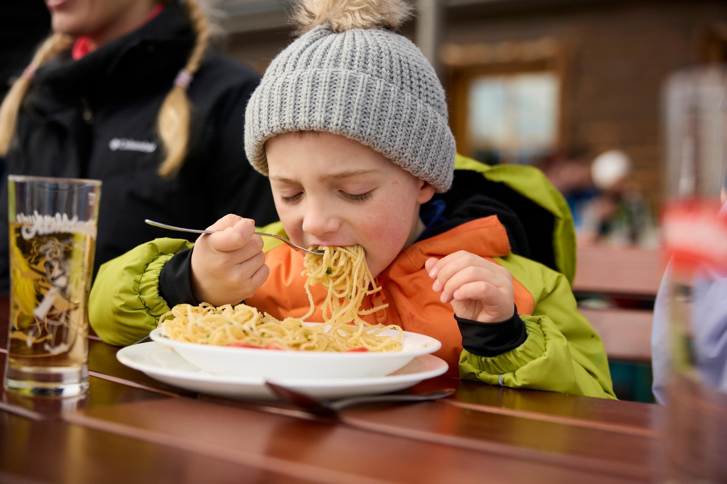 Kindergesicht beim Essen im Aldiana Premium Cluburlaub, draußen an einem Tisch.